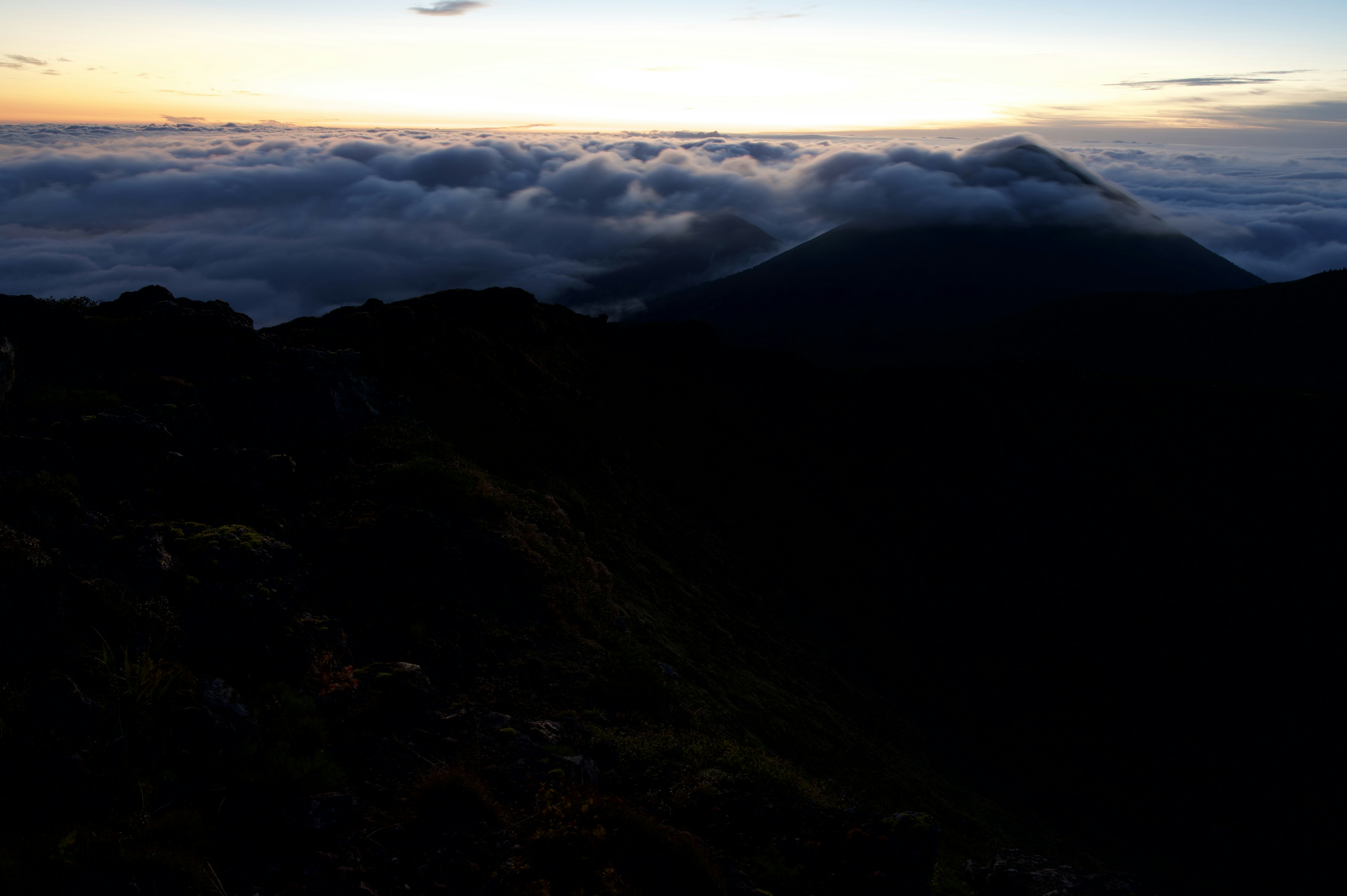 Vista della copertura nuvolosa e del tramonto da una cima montuosa