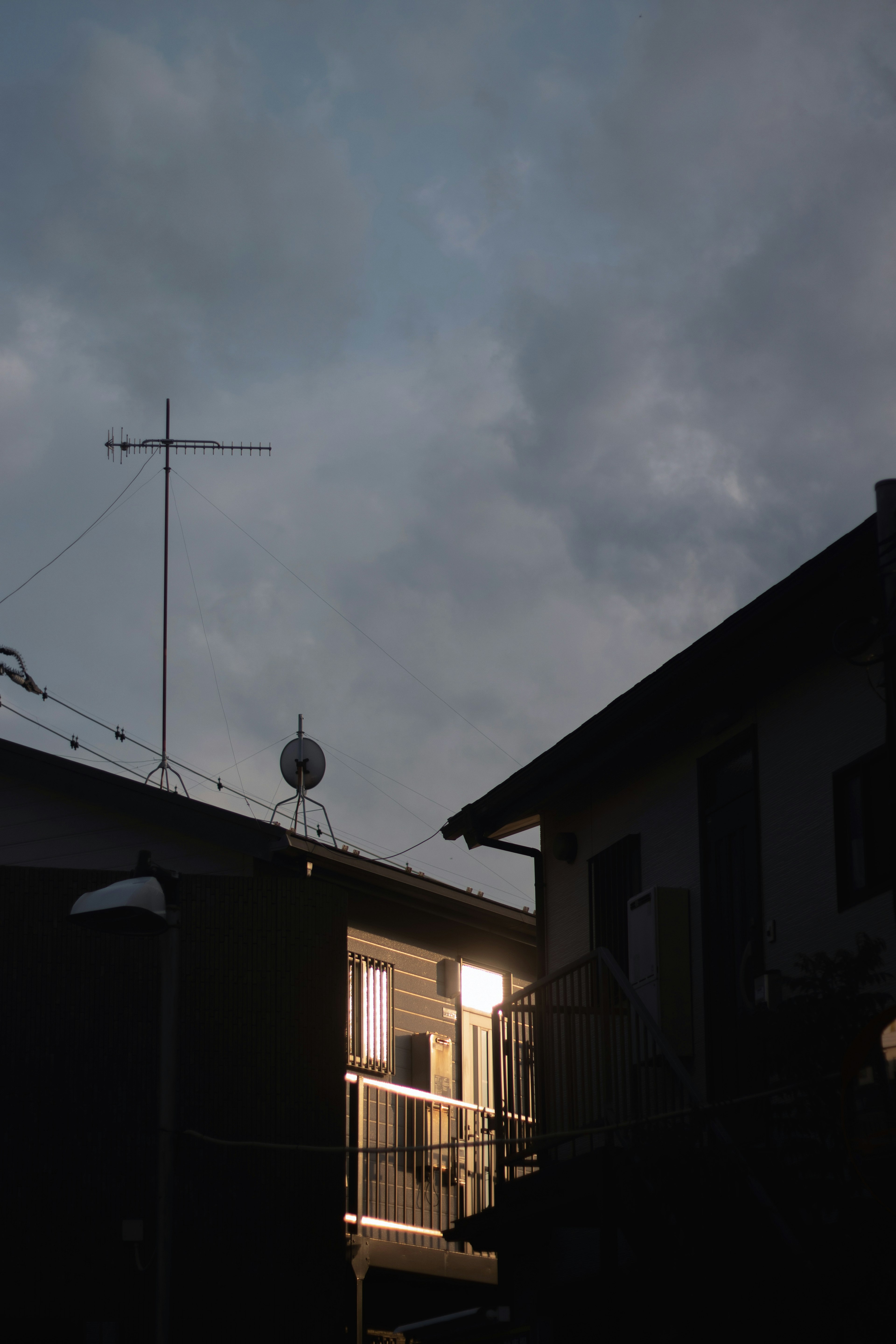 Illuminated building under a dark sky with antennas