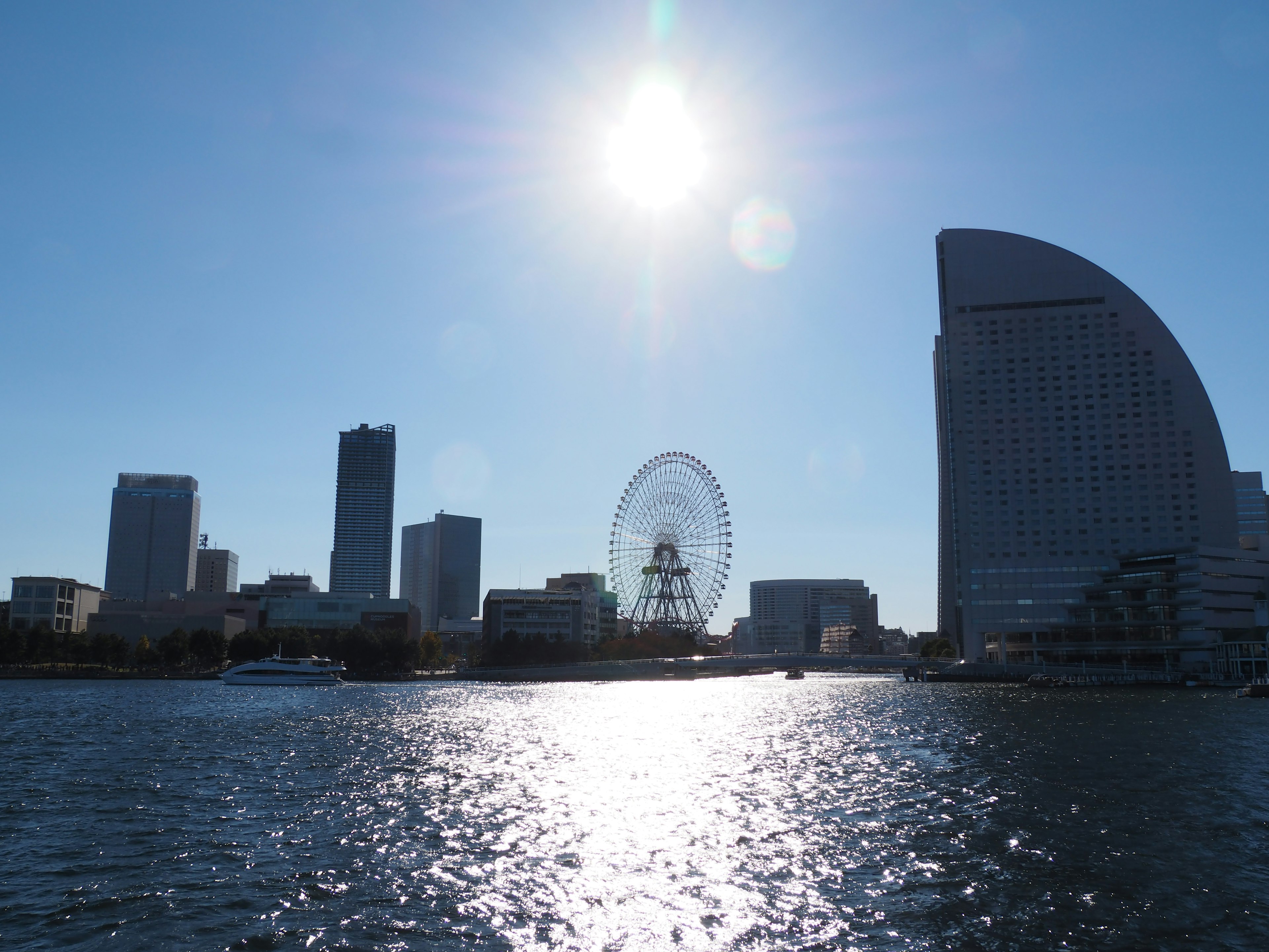 Siluet roda raksasa dan gedung pencakar langit di sepanjang tepi laut Yokohama