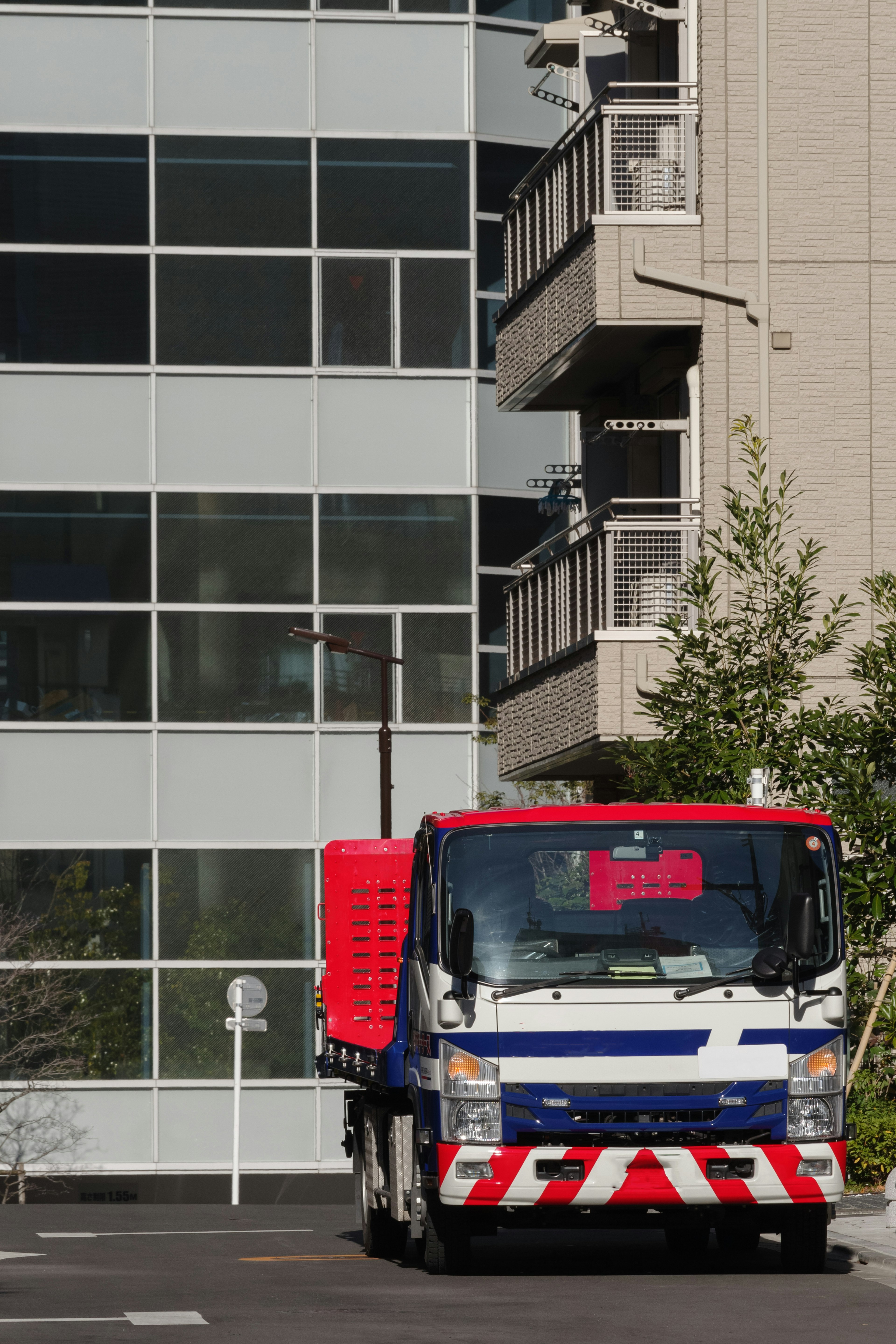 A truck with red baskets parked in front of a glass building