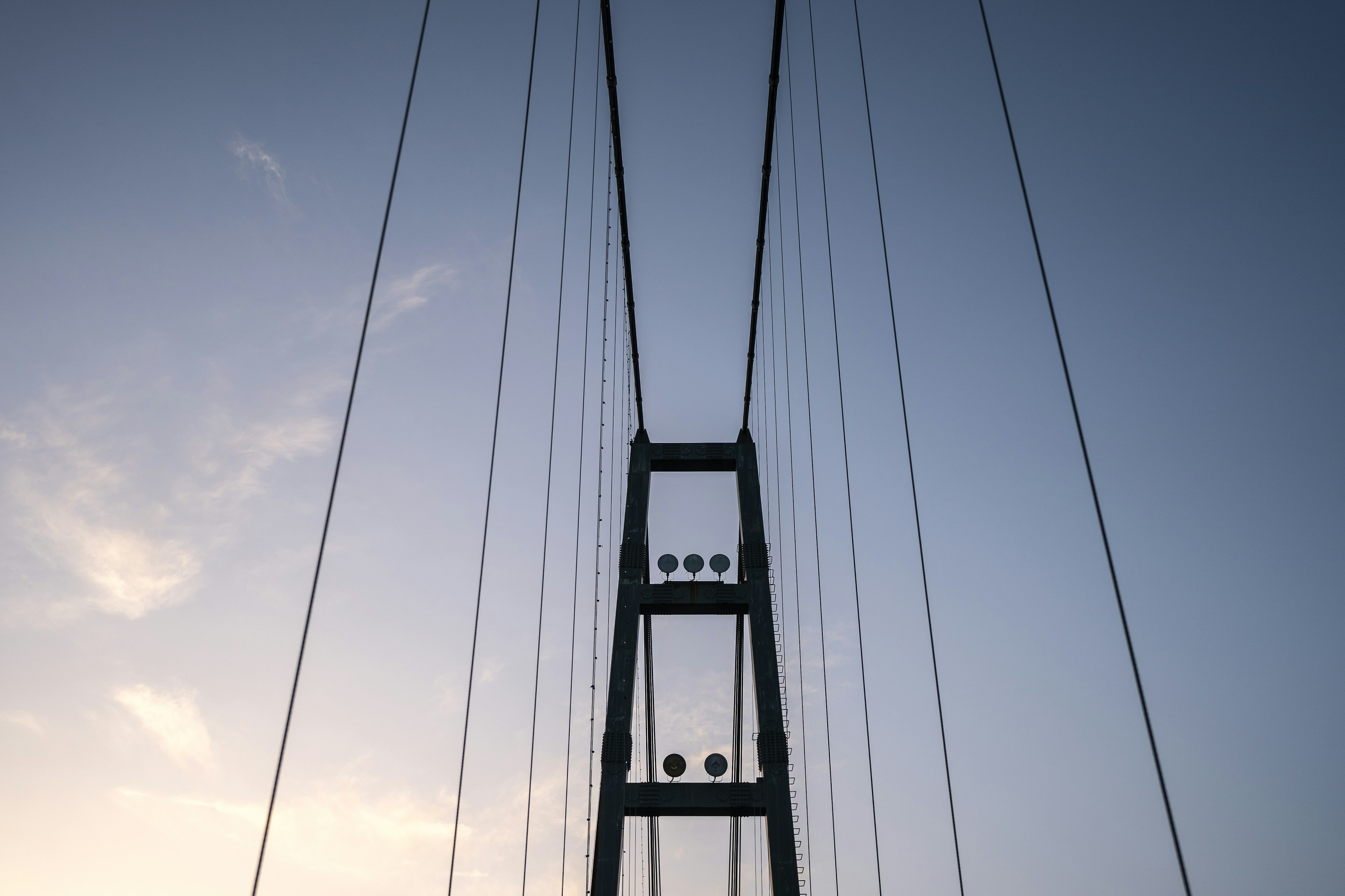 Turm und Kabel einer Hängebrücke vor blauem Himmel