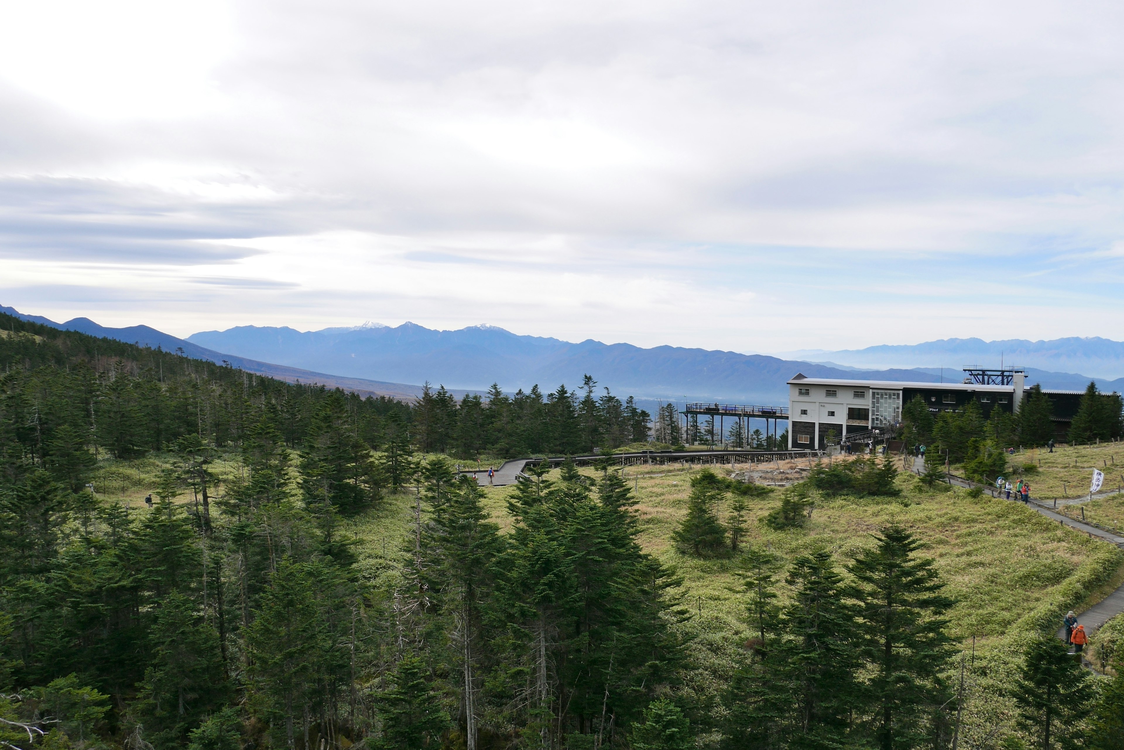 Paysage montagneux vaste avec un bâtiment moderne au milieu de la verdure