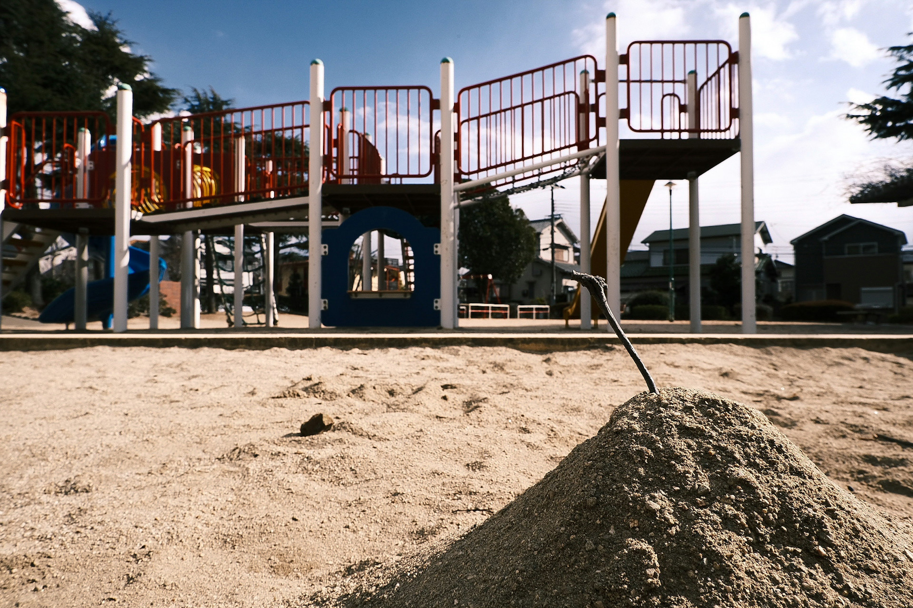 Escena de parque infantil con un montón de arena y un tobogán