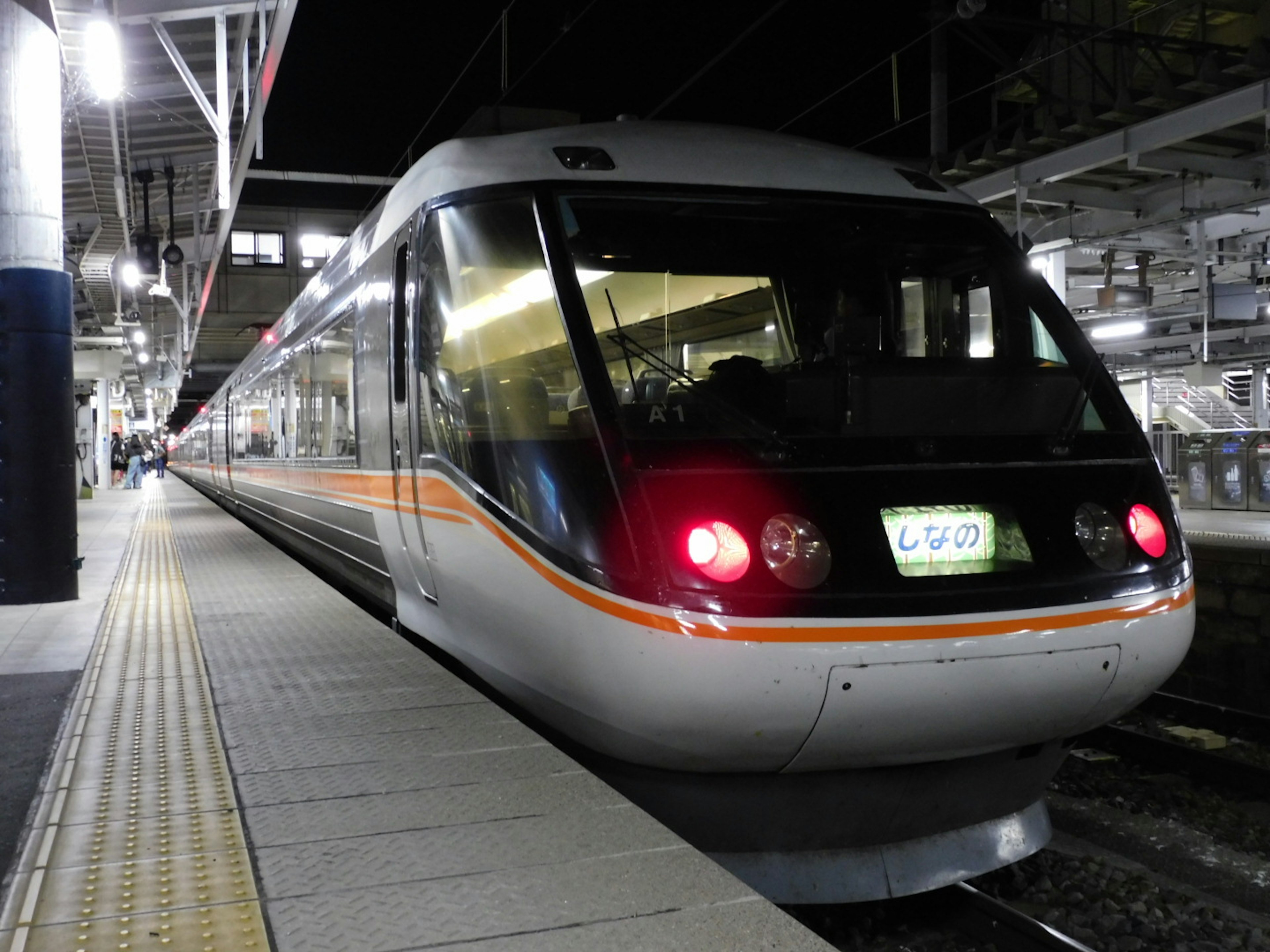 A modern train stopped at a station at night