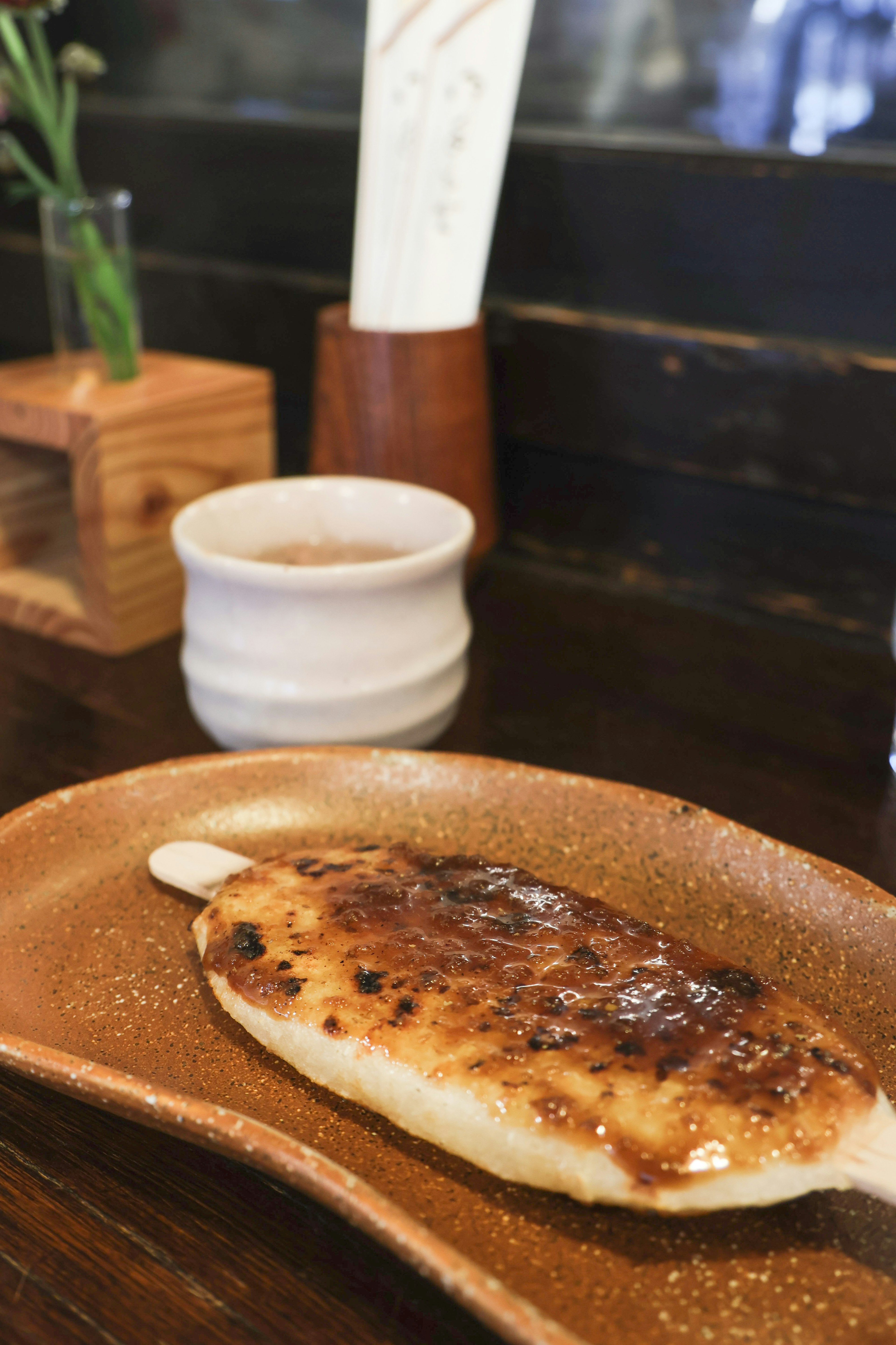 Pastel de arroz a la parrilla servido en un plato con una taza de té