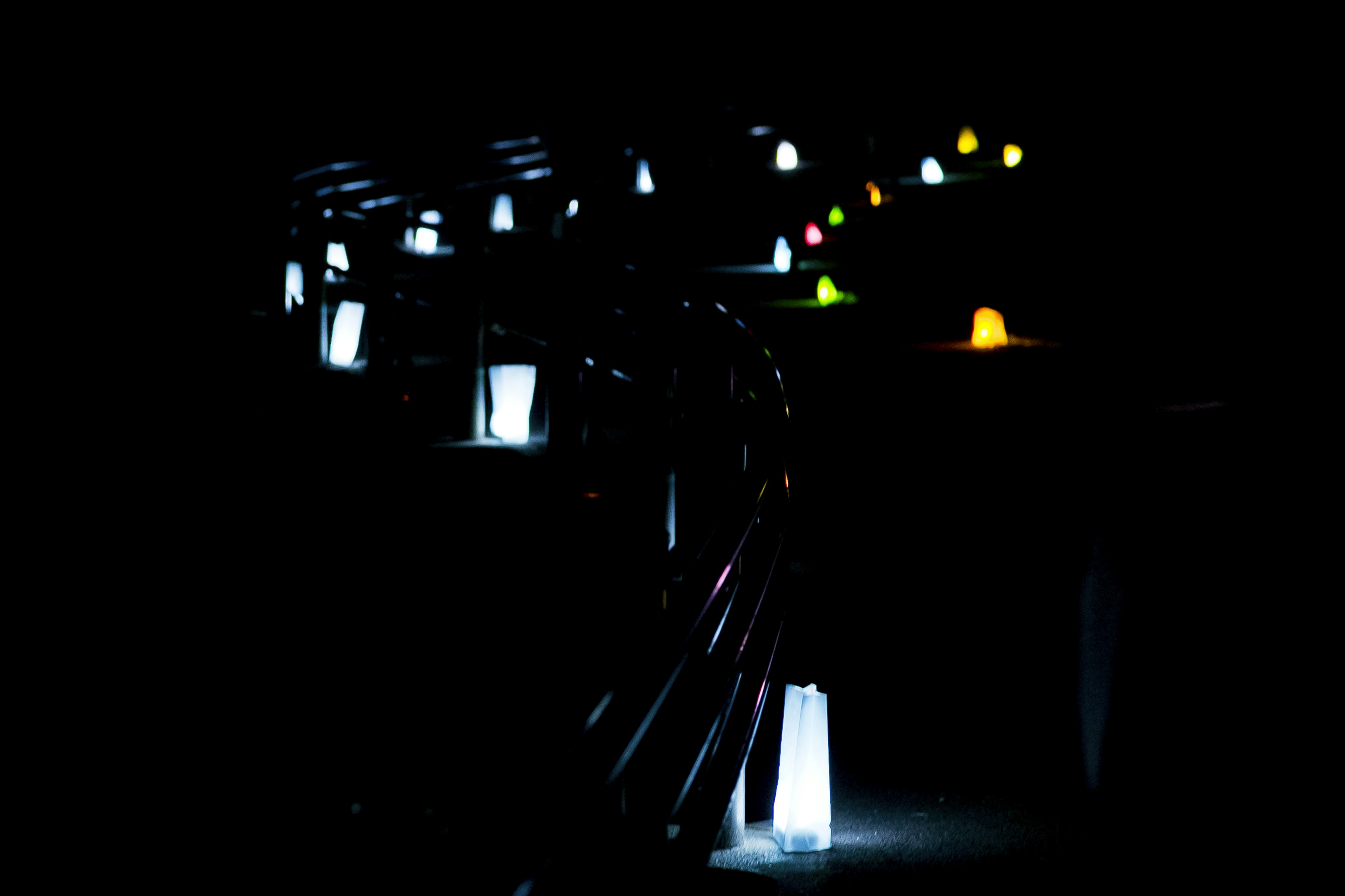 Des lanternes colorées alignées sur un escalier dans un fond sombre