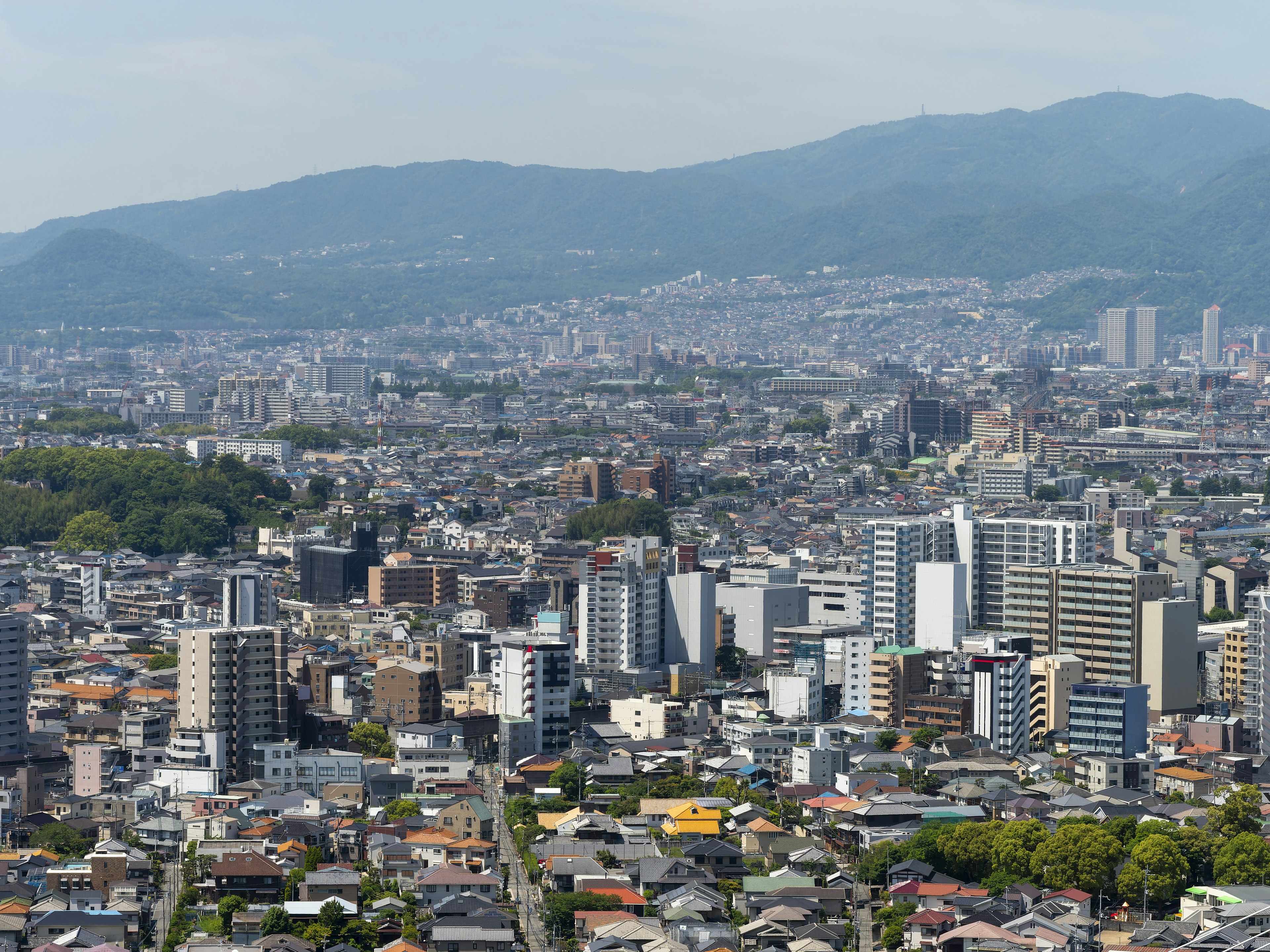 Pemandangan panorama kota Kyoto dengan gedung tinggi dan pegunungan