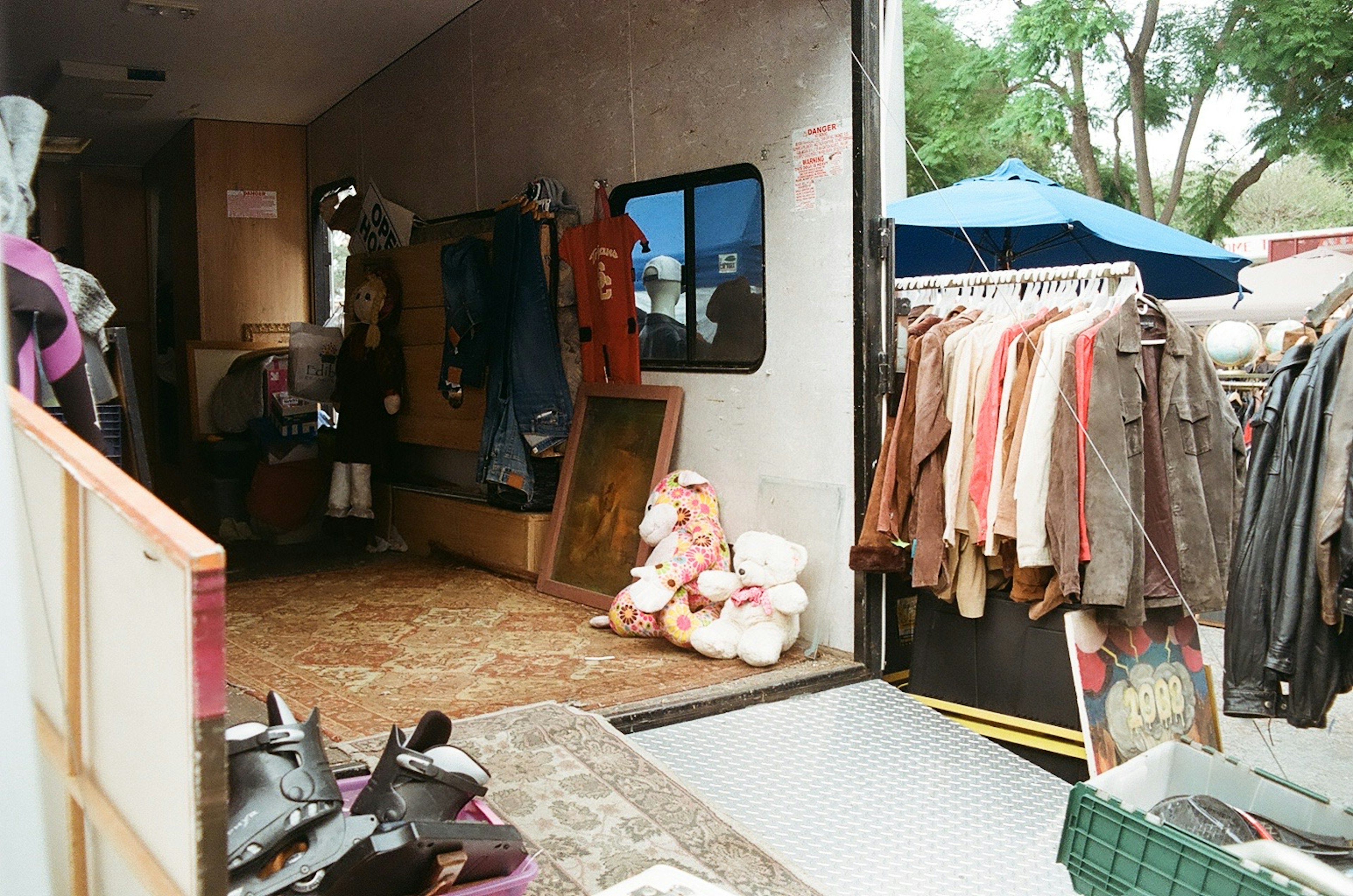 Interior of a vintage clothing stall with various garments and decorations