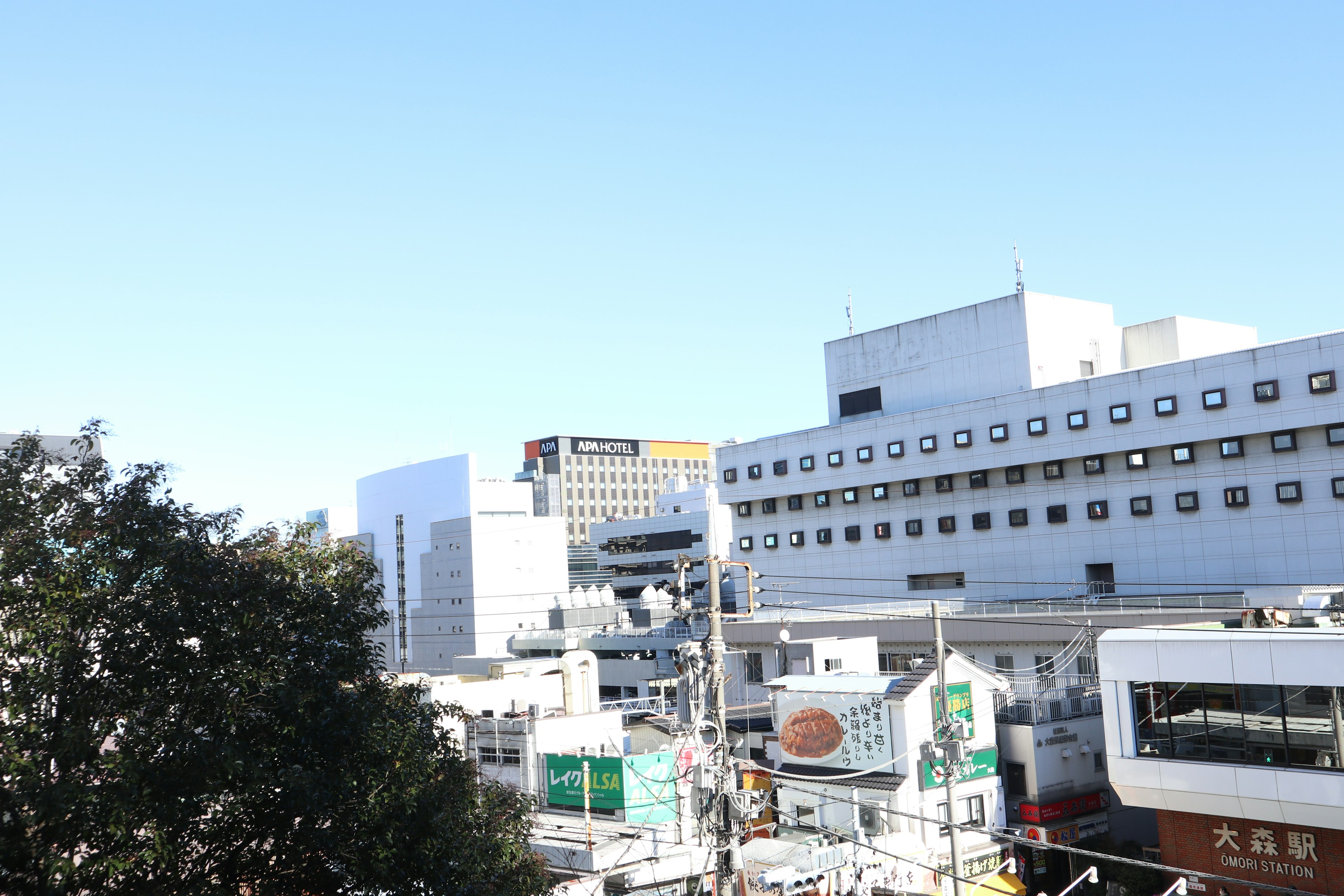 Paysage urbain sous un ciel bleu avec des bâtiments modernes et une zone commerciale