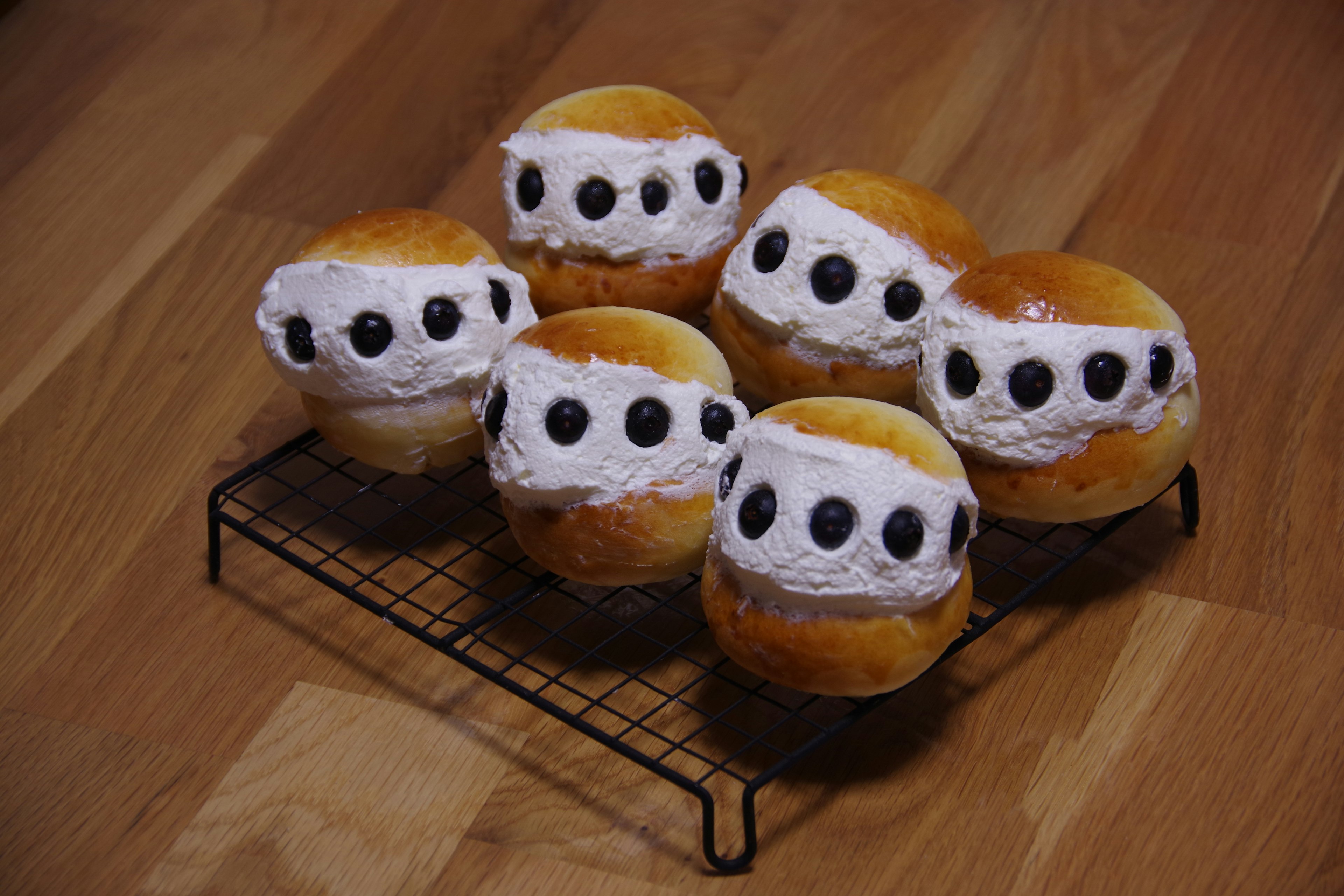 Fluffy bread topped with cream and olives arranged on a wire rack