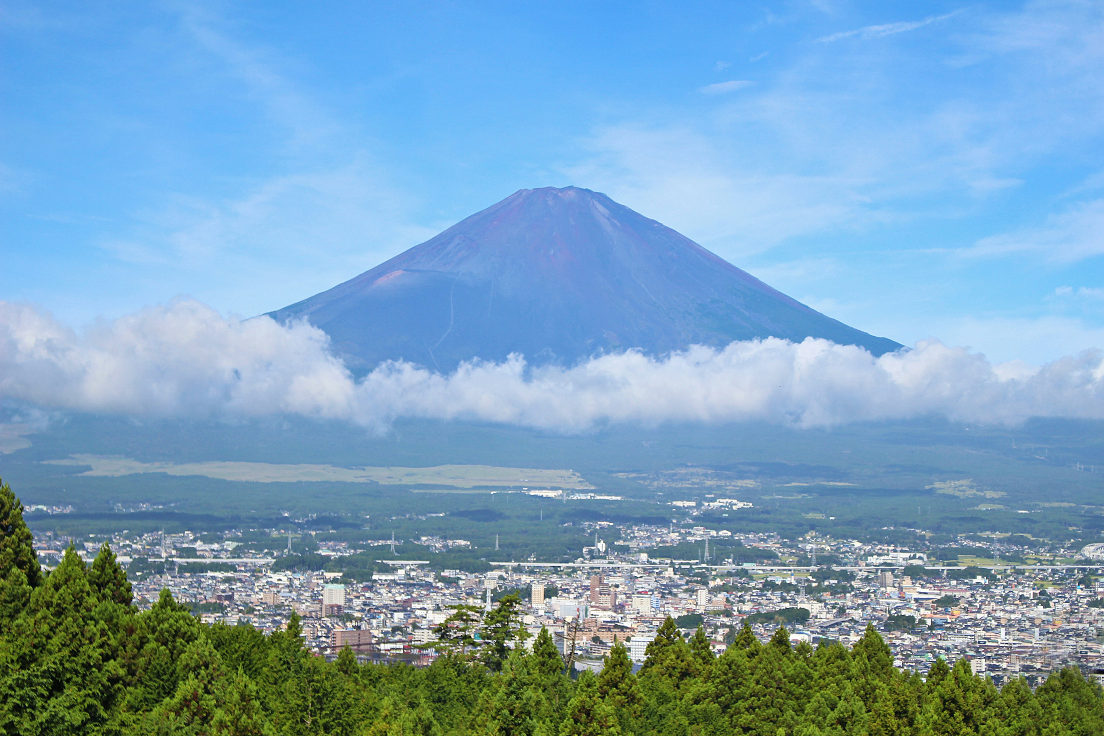 ภูเขาฟูจิพร้อมทิวทัศน์เมืองรอบๆ ท้องฟ้าแจ่มใสและเมฆ