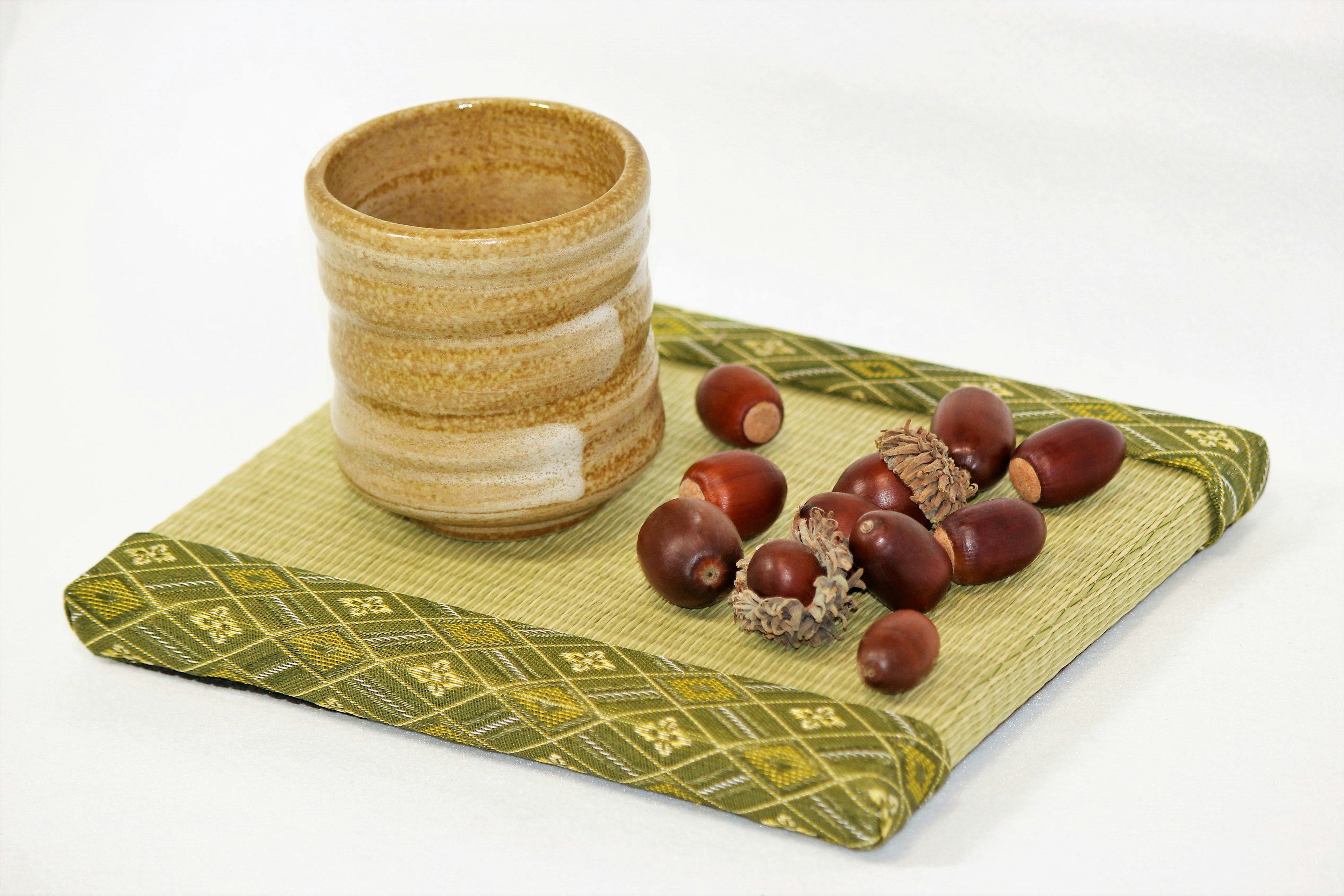 Ceramic cup with brown fruits on a green tray