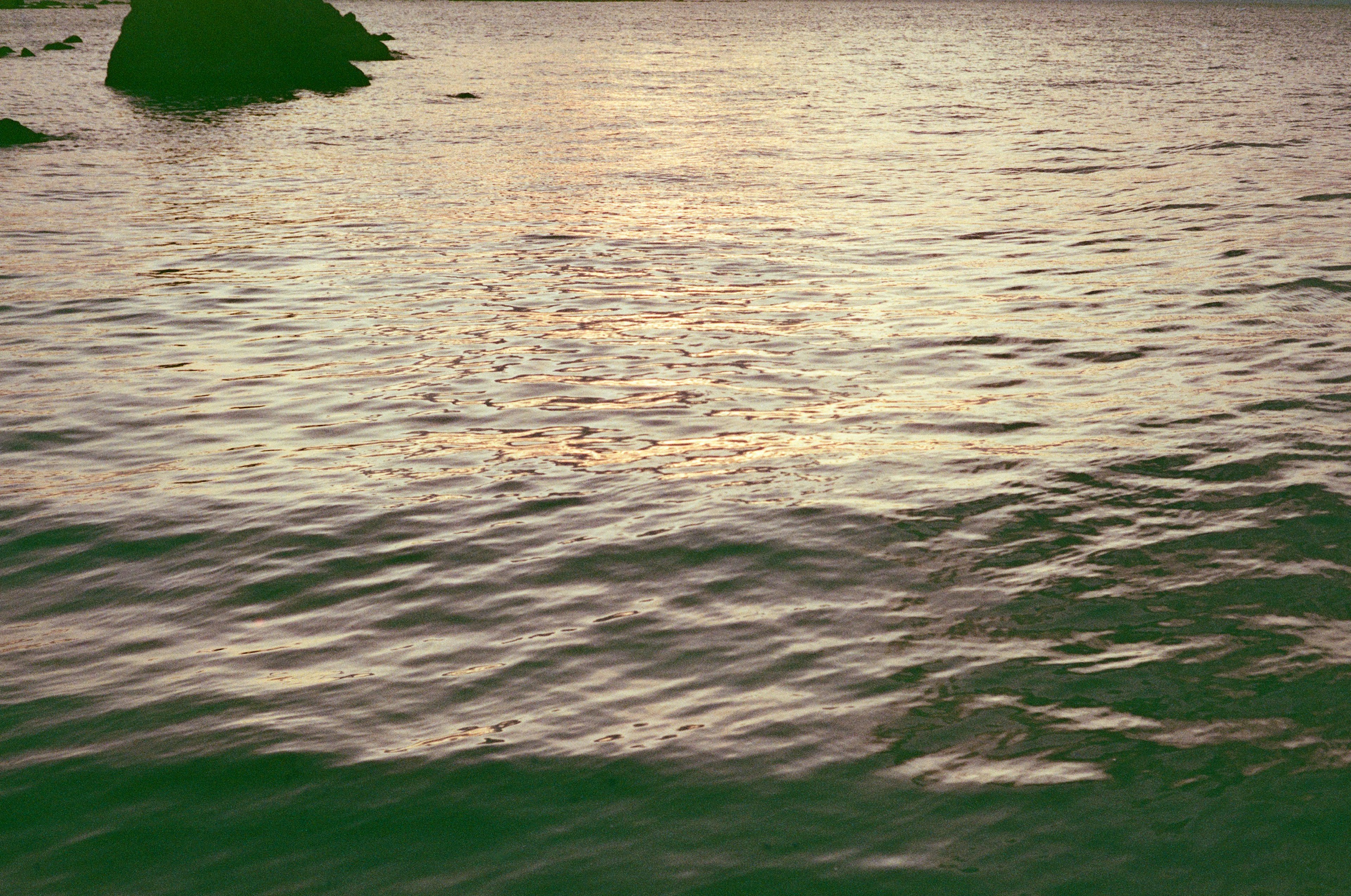 Surface d'eau ondulante reflétant le coucher de soleil sur la mer