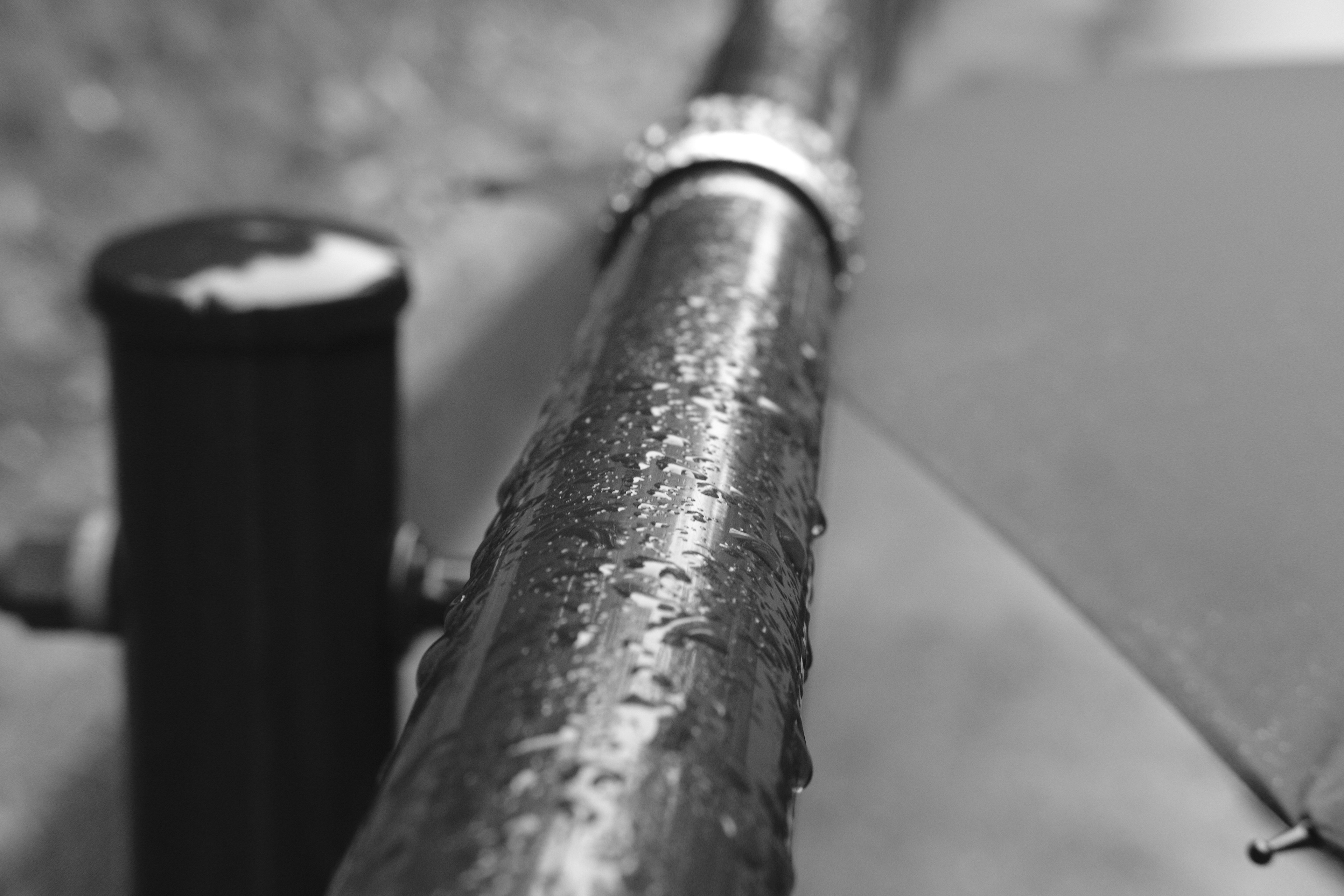 Close-up of a wet pipe in black and white