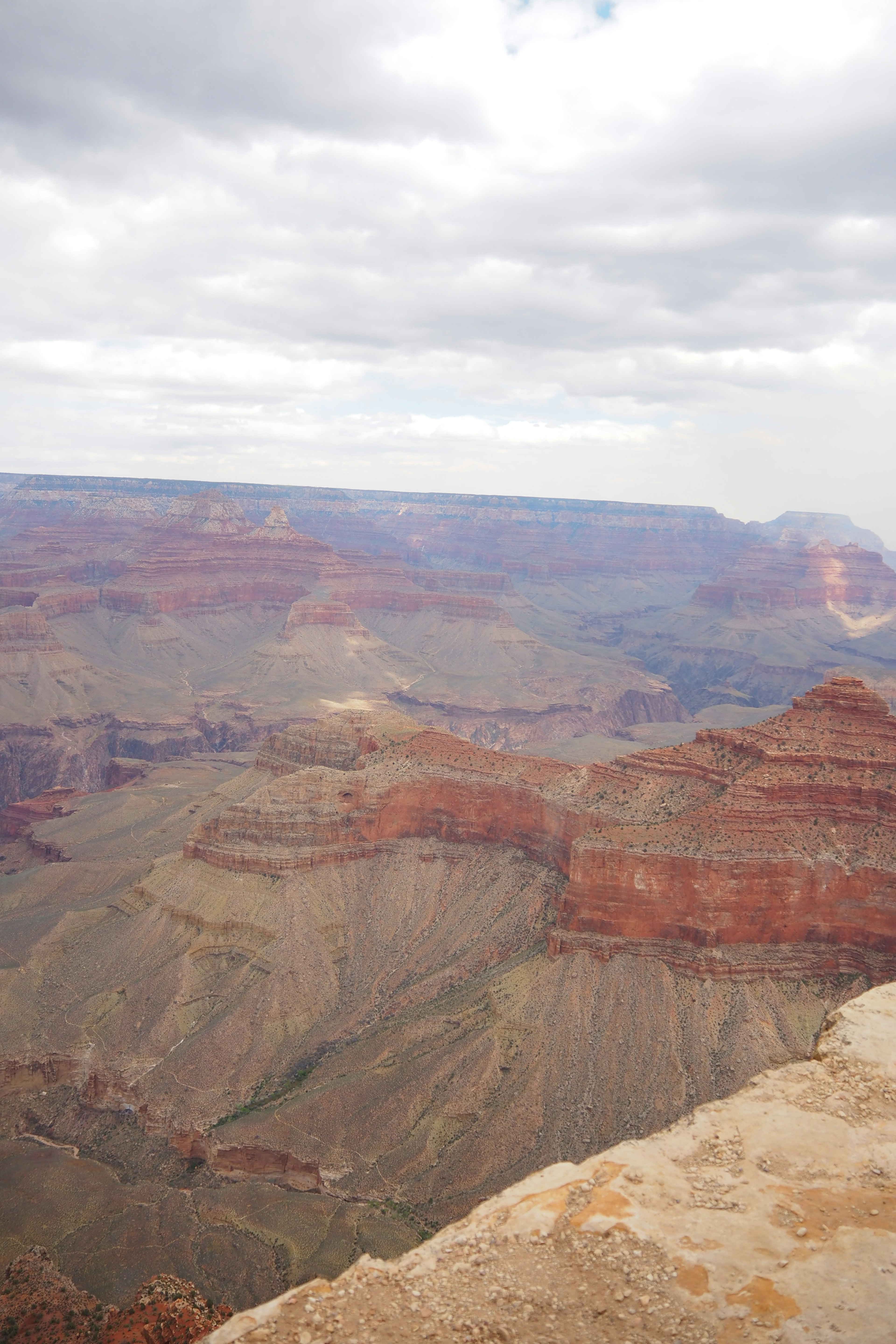 Pemandangan menakjubkan Grand Canyon dengan lapisan batu merah dan langit berawan