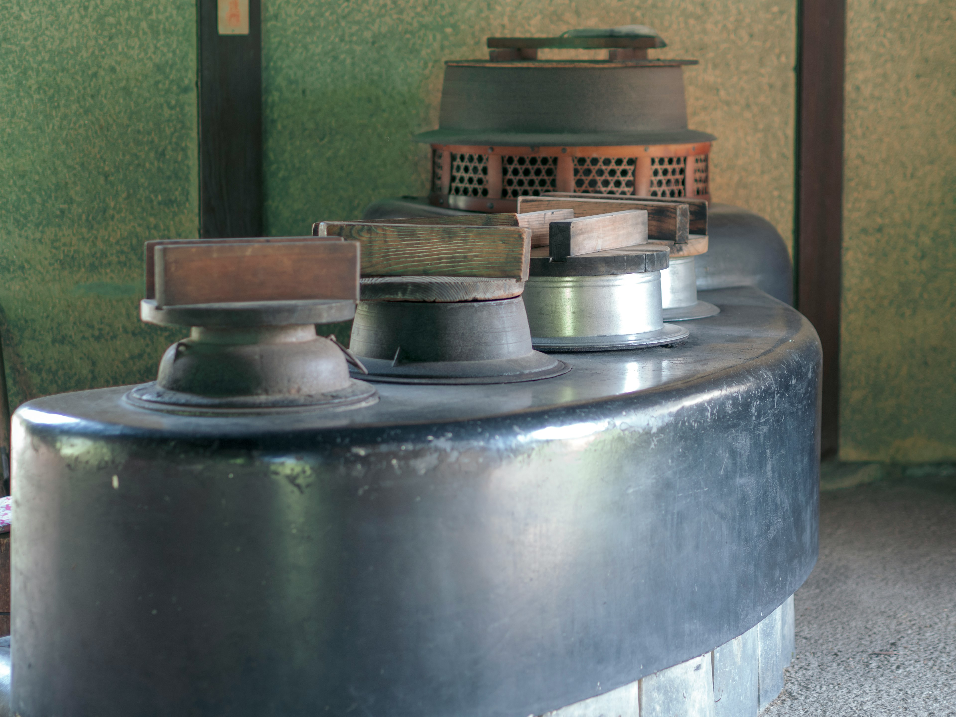 Interior view featuring a row of black circular stoves and metal components