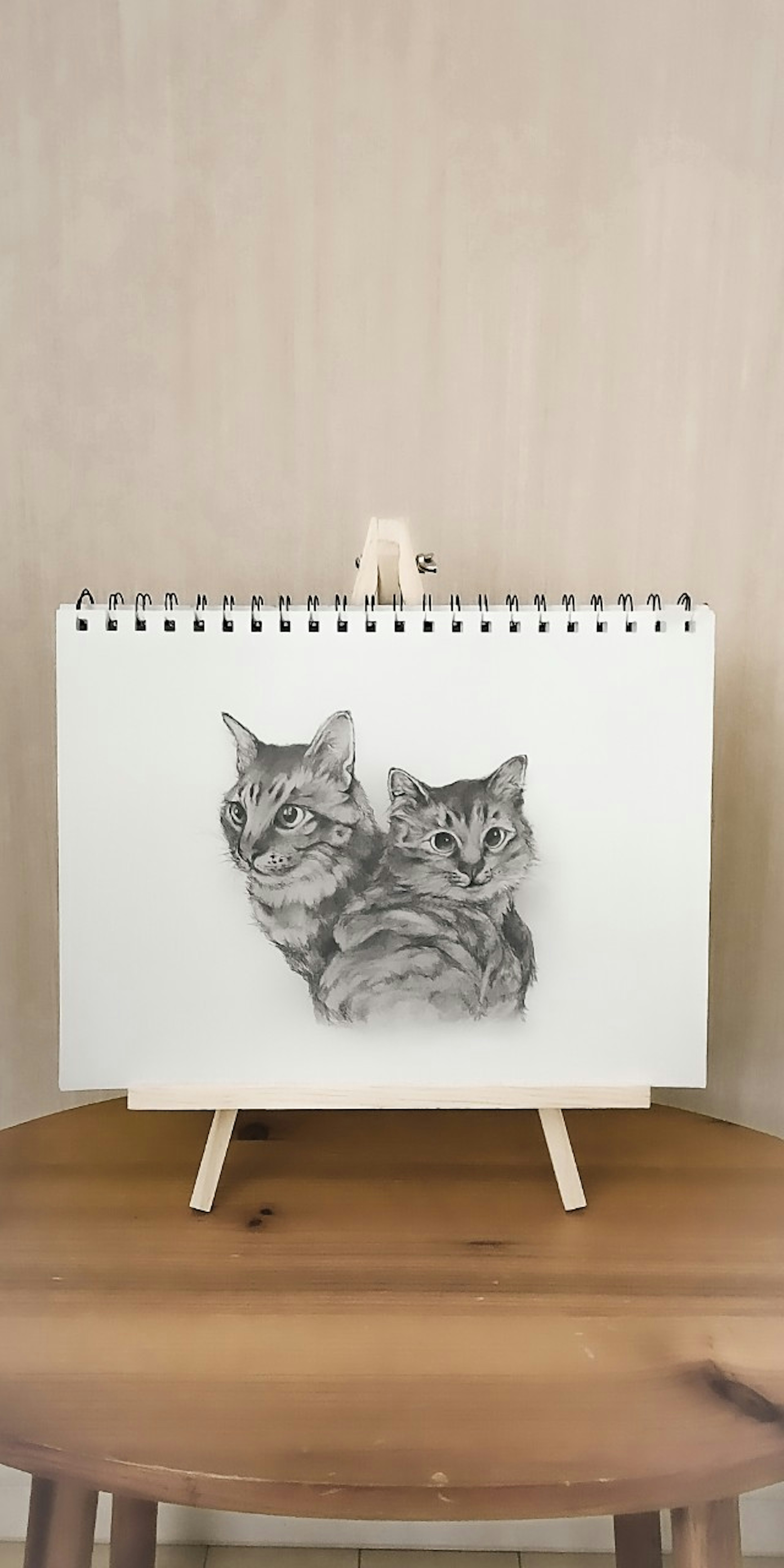 二匹の猫のスケッチが描かれたカレンダーが木製のテーブルの上に置かれている