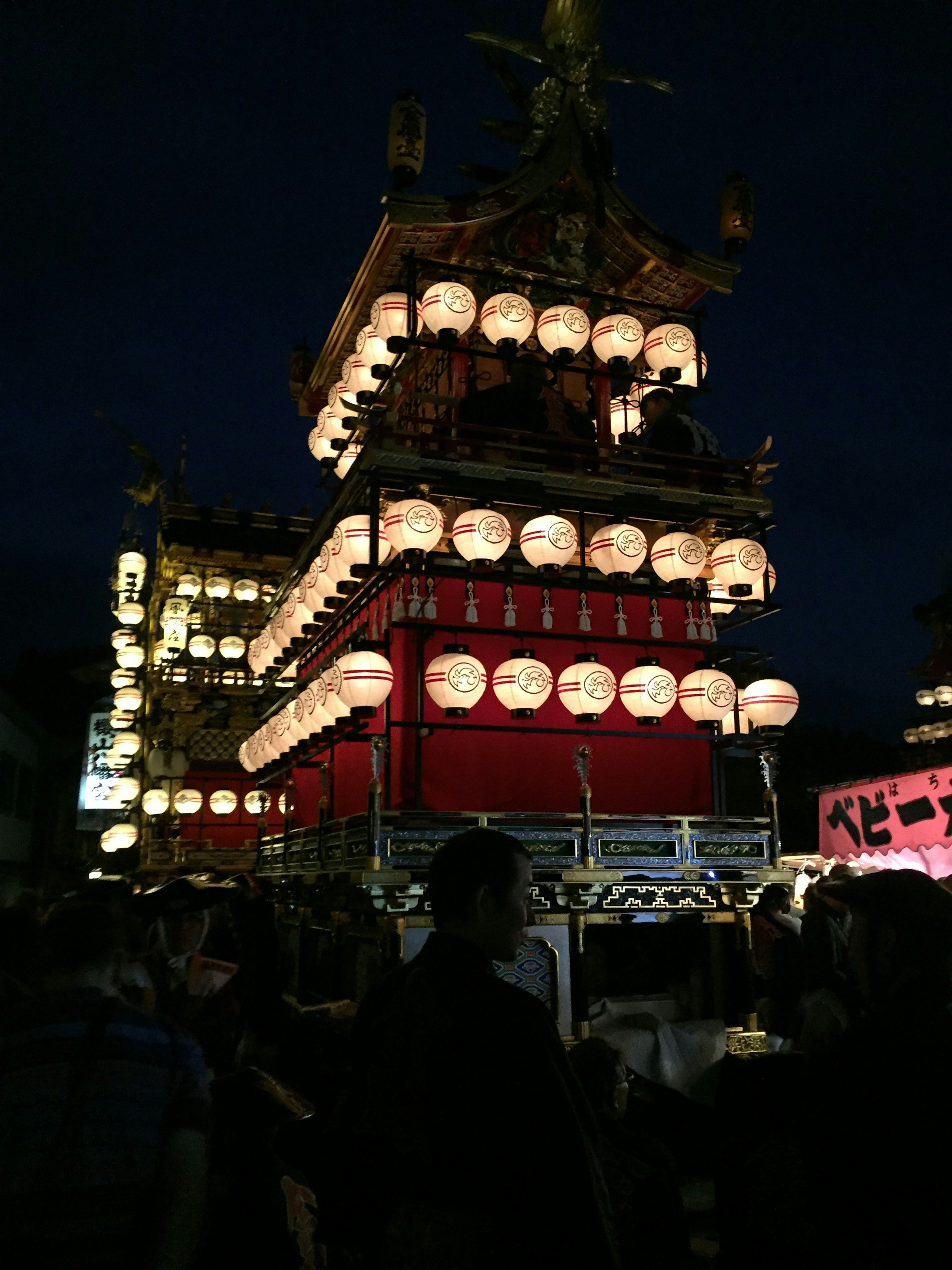 Scena di festival con lanterne illuminate su un carro di notte