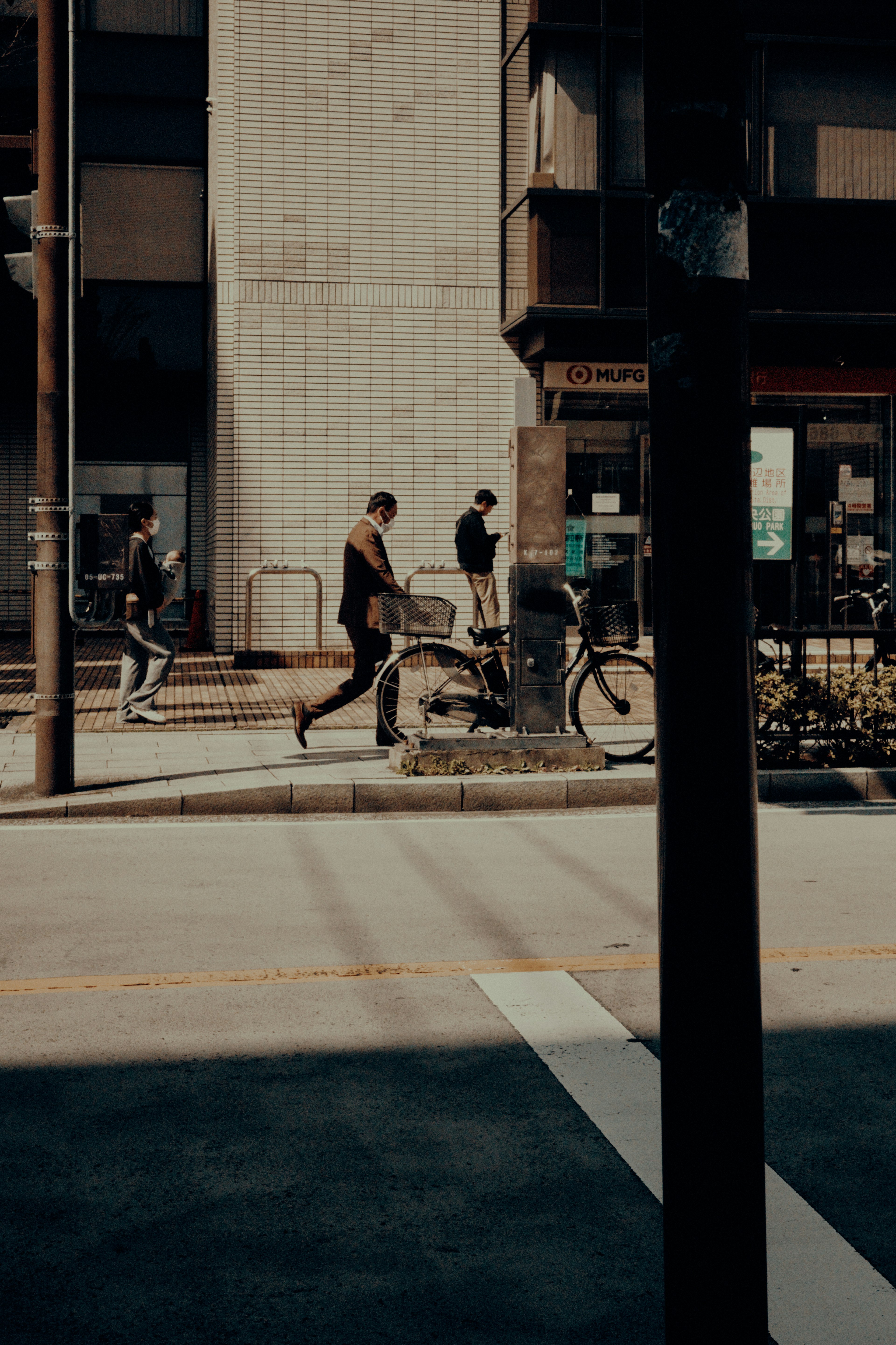 City scene with people walking and bicycles visible