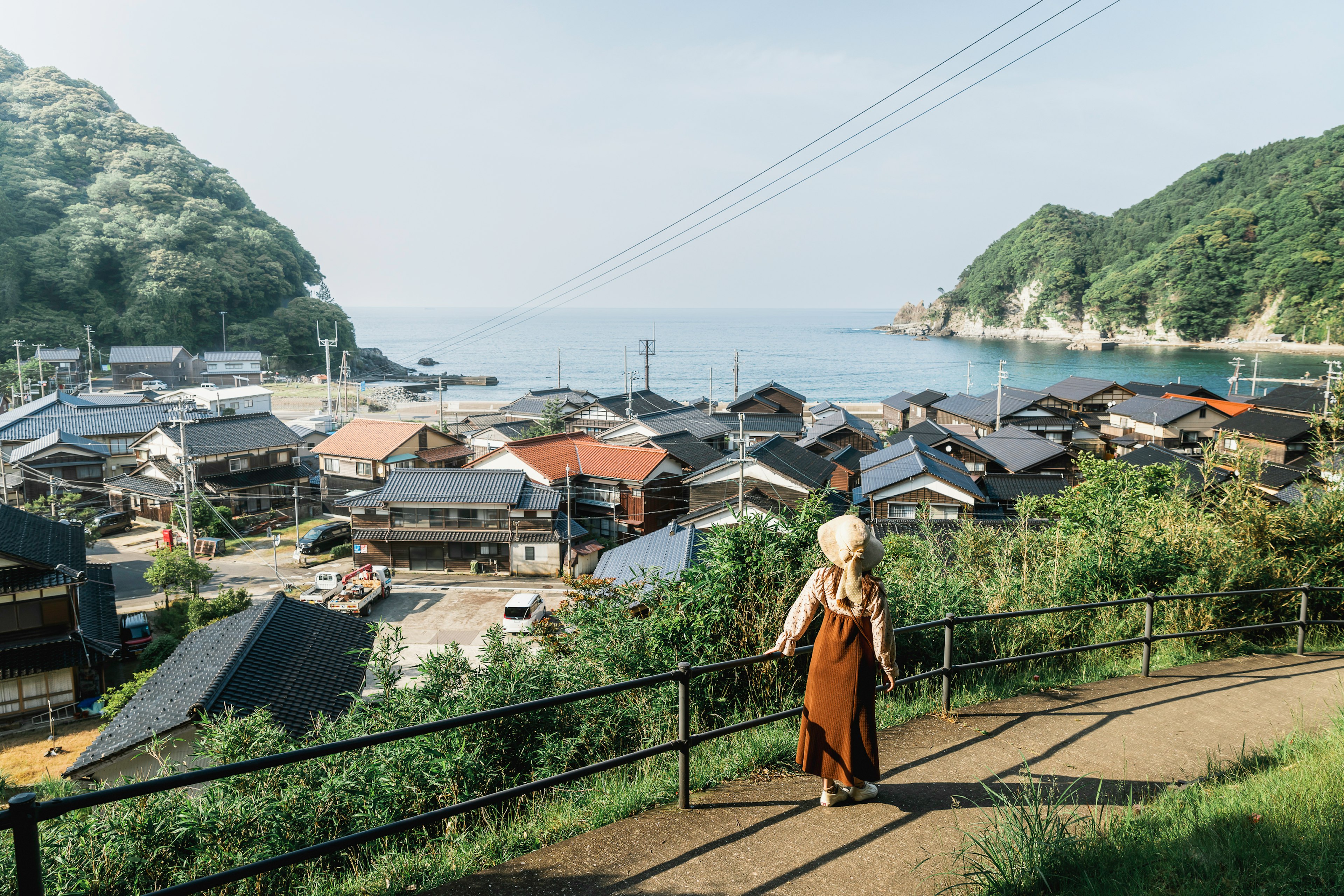 海の見える美しい村を散策する女性