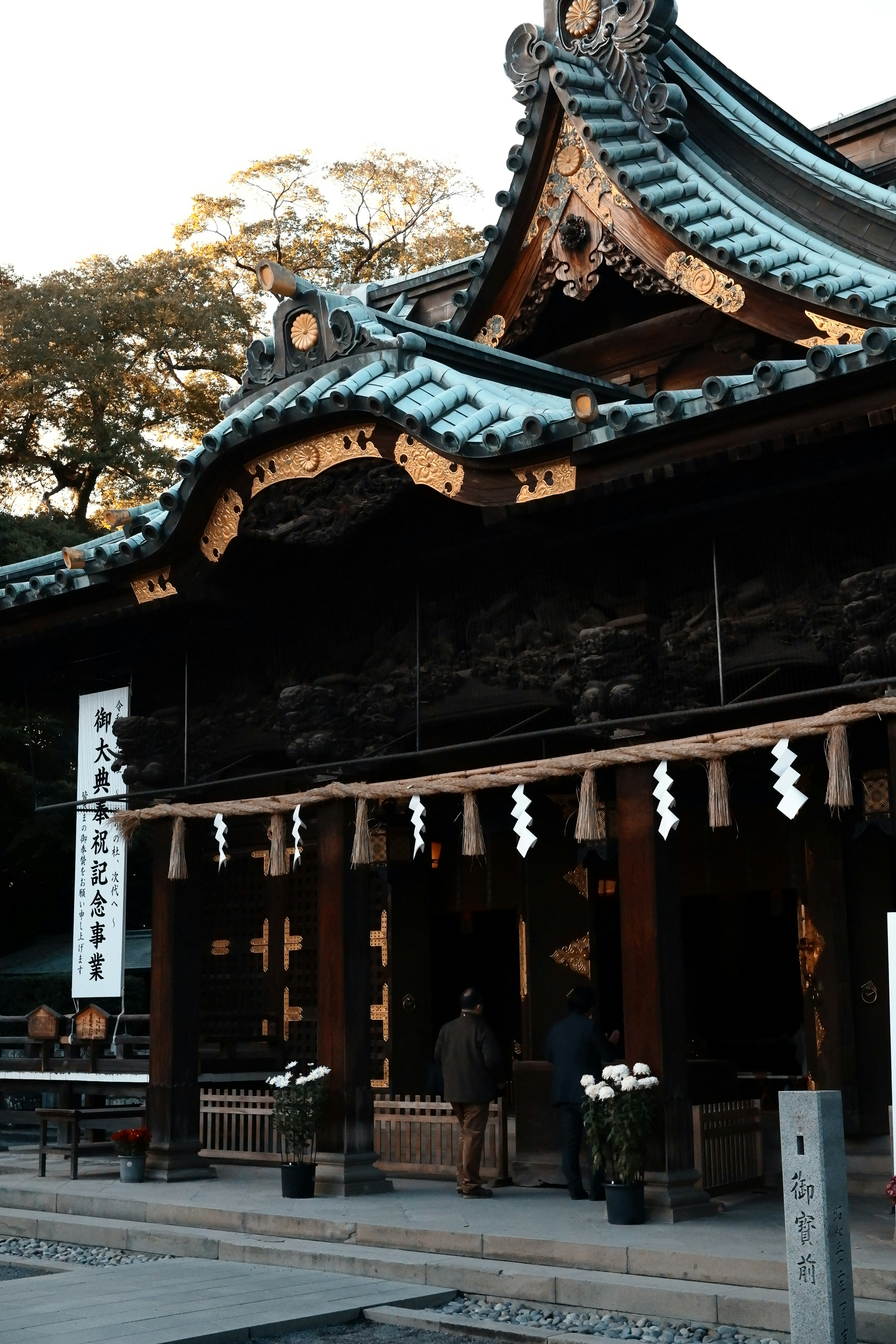 Santuario japonés tradicional con techo ornamentado y visitante