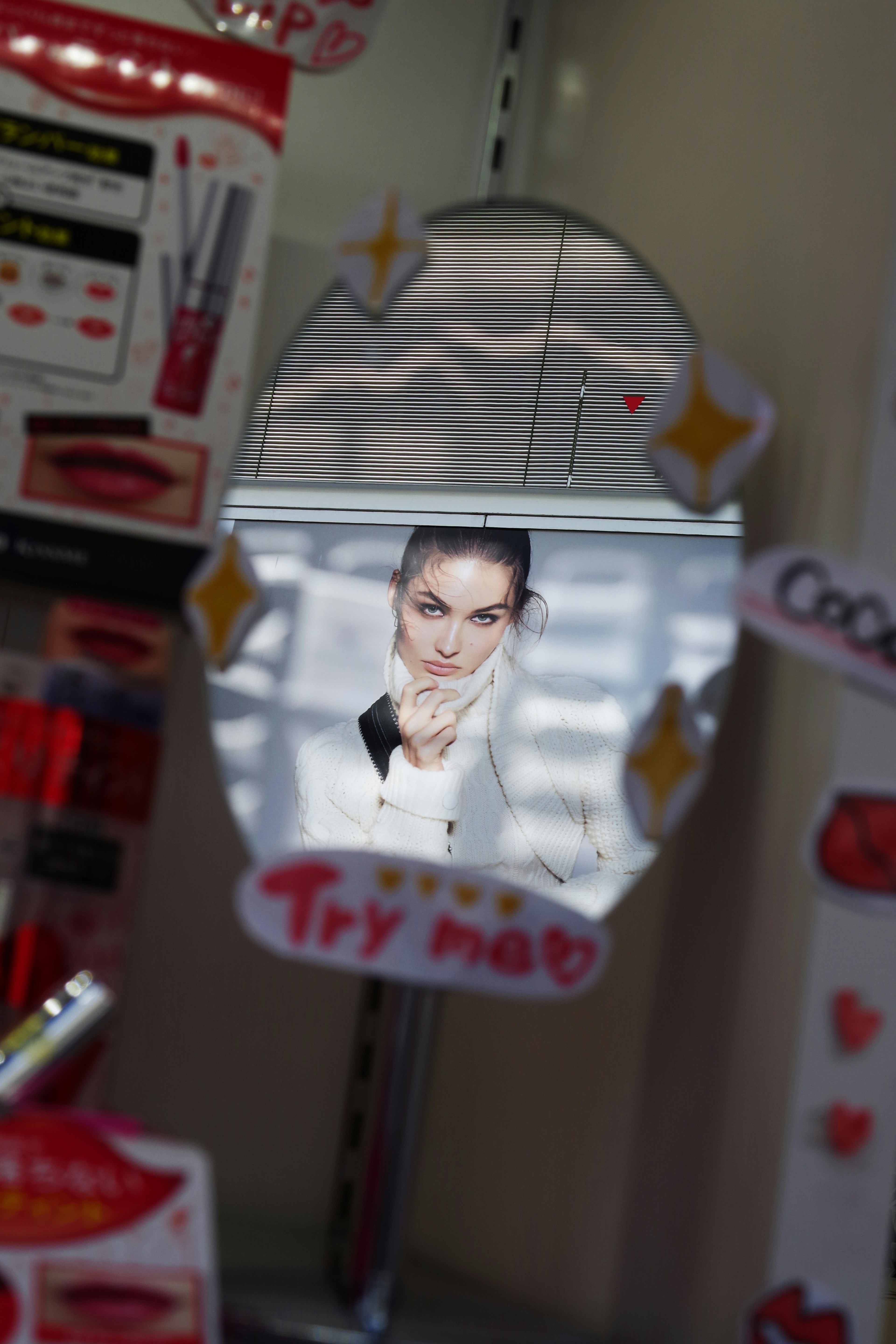 Reflection of a woman's face in a mirror with cosmetics display