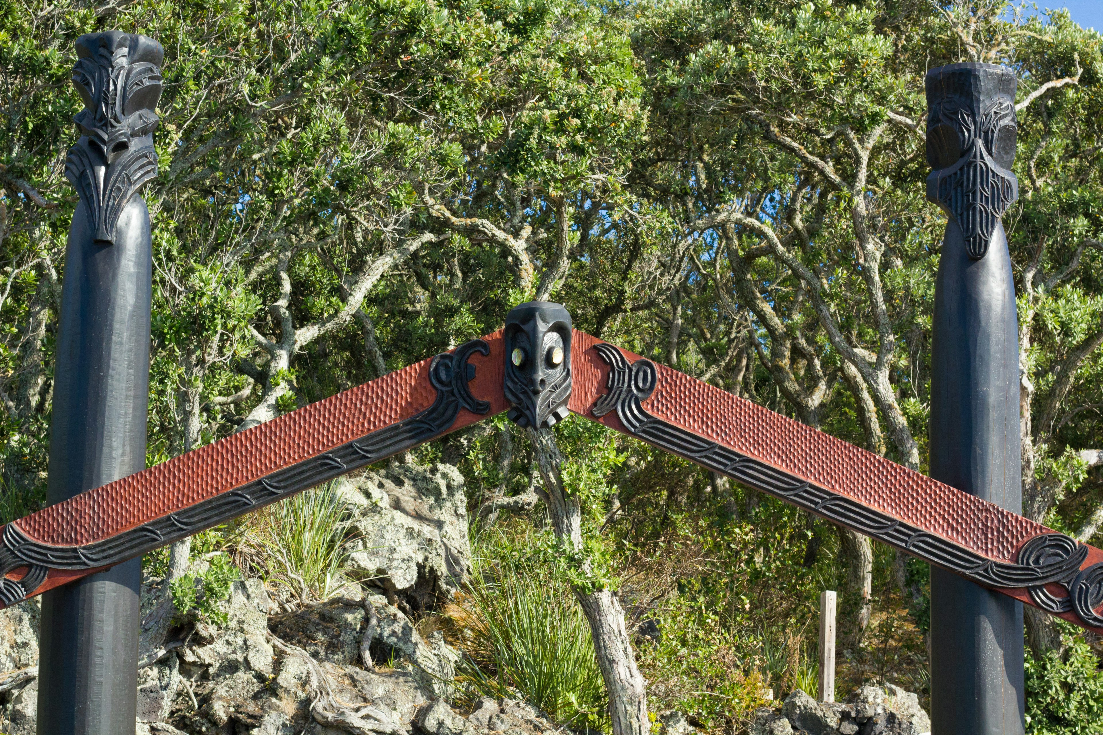 Structure en bois avec décoration rouge et colonnes noires dans un cadre naturel