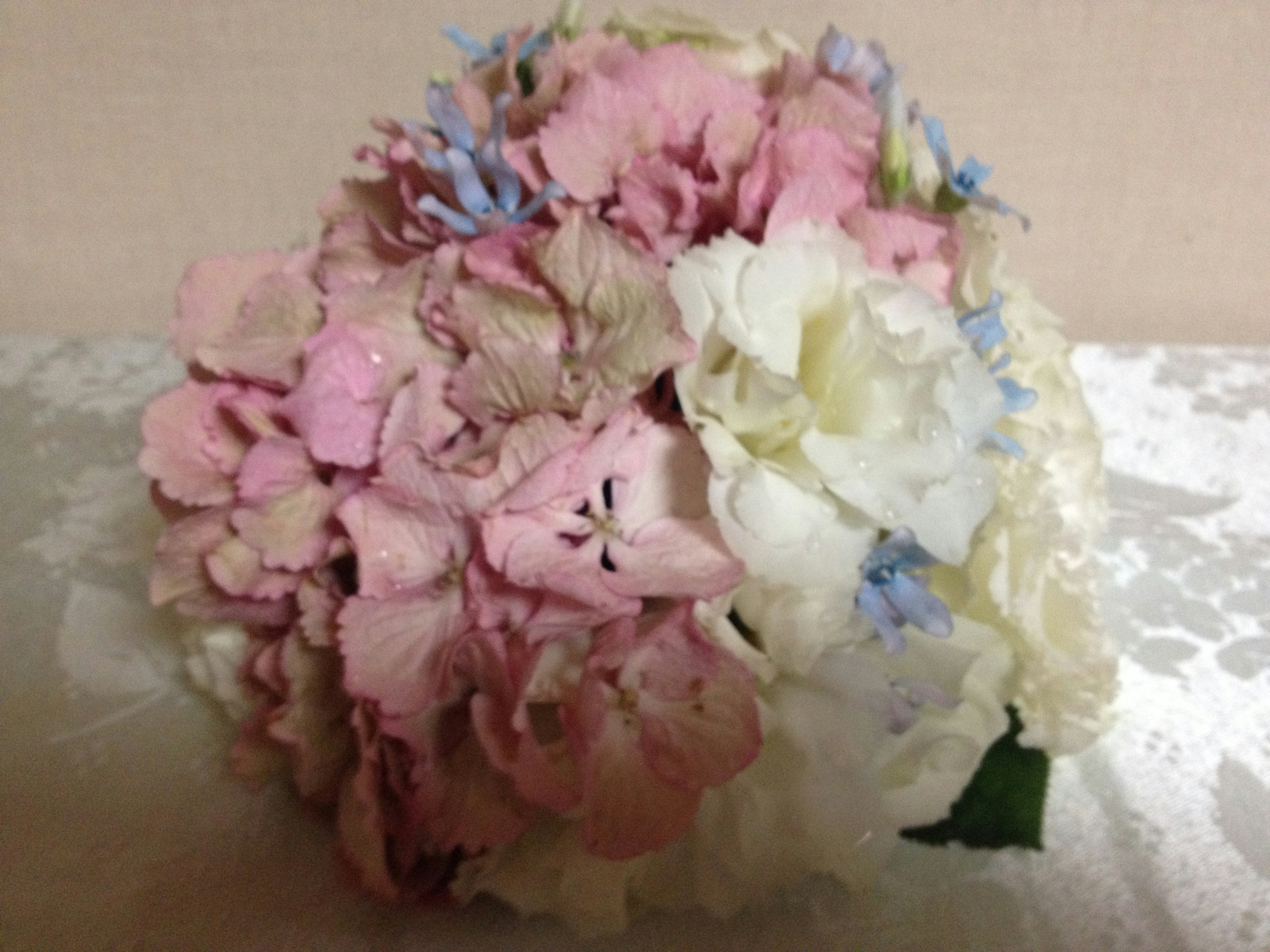 Bouquet de fleurs roses et blanches avec des accents bleus couleurs douces