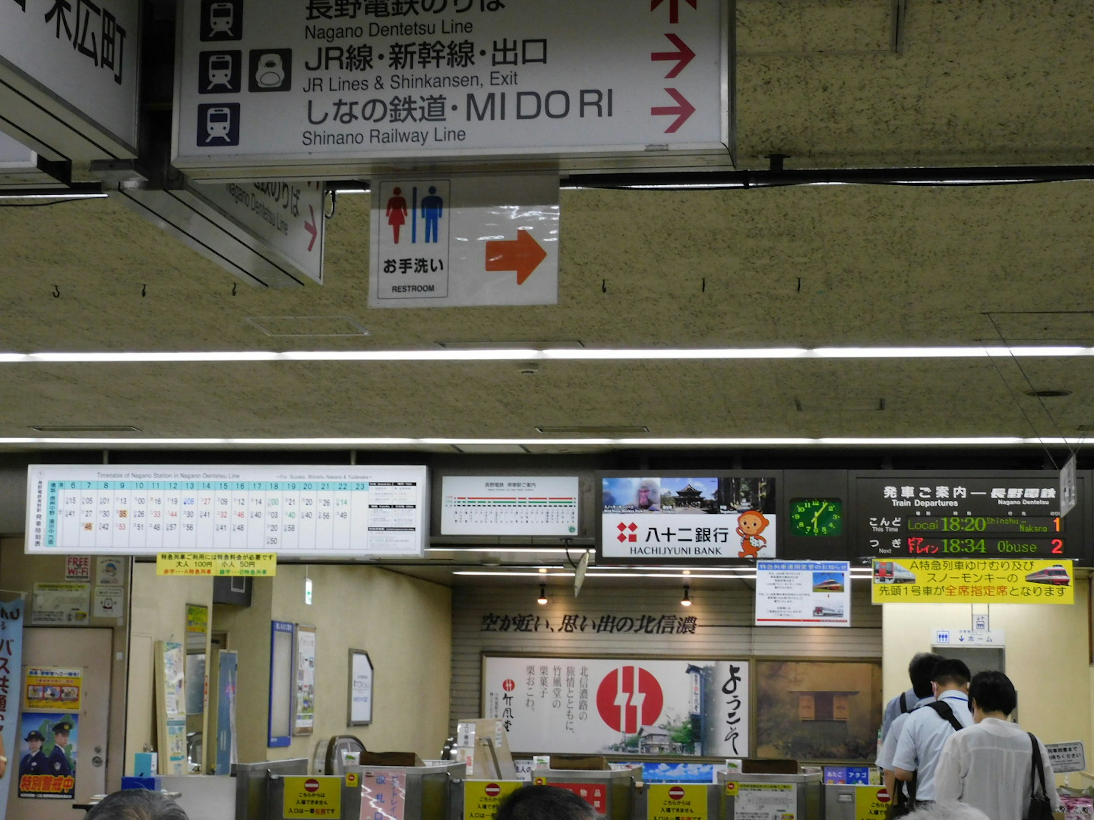 駅の案内サインと人々がいる風景