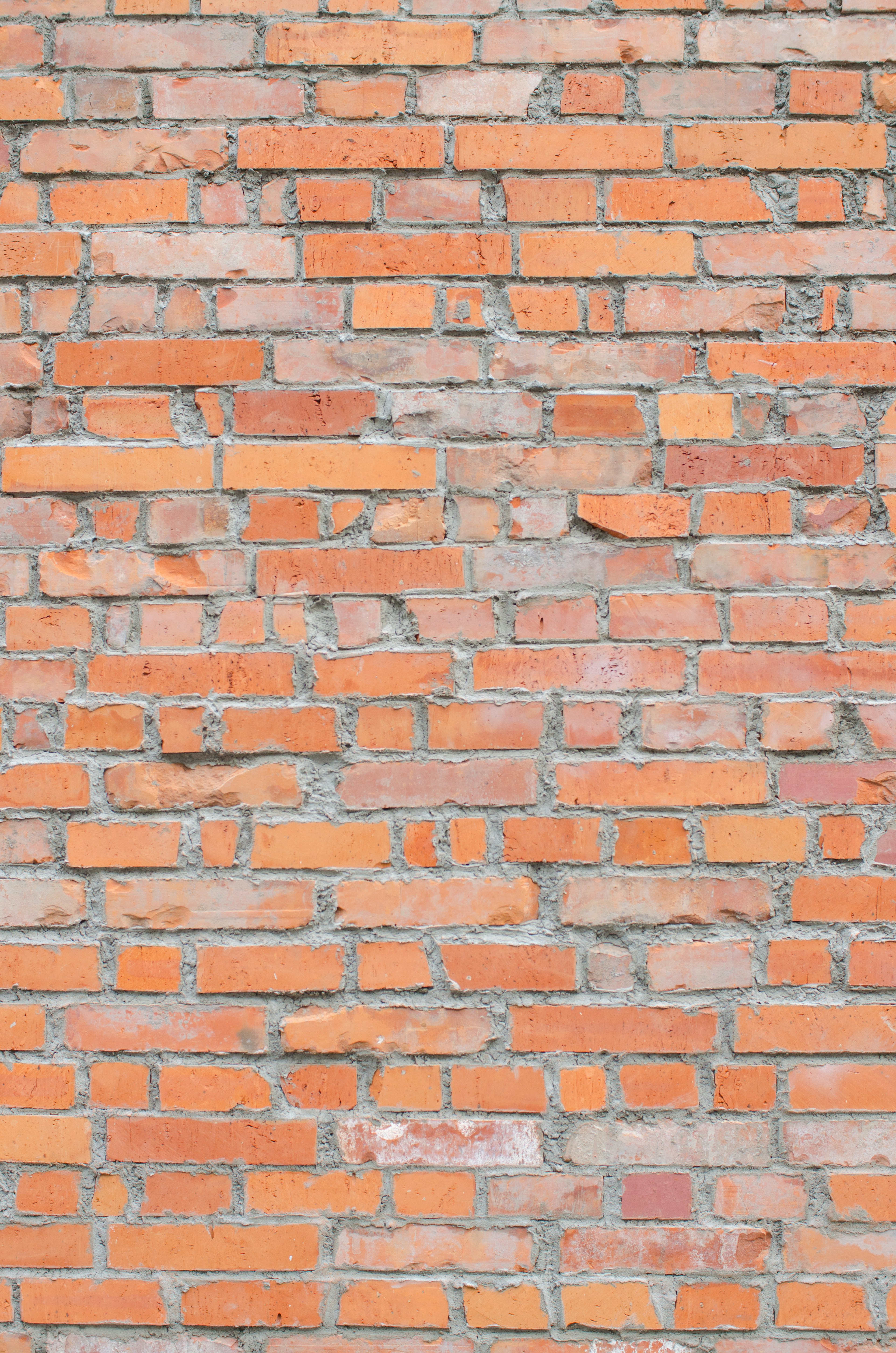 Textured brick wall with warm orange tones and variations