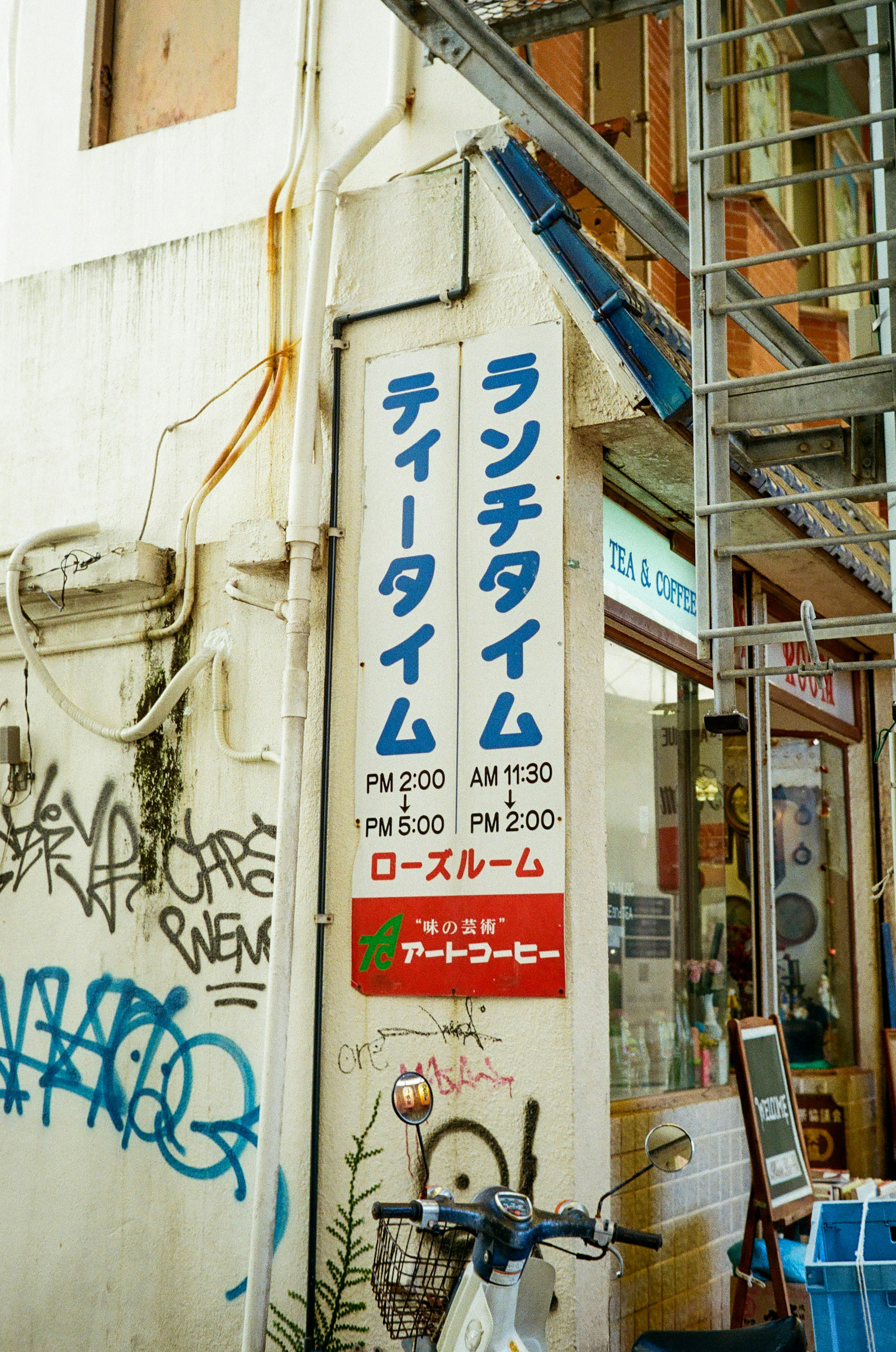 Street corner view featuring a lunch time sign and a bicycle on the wall