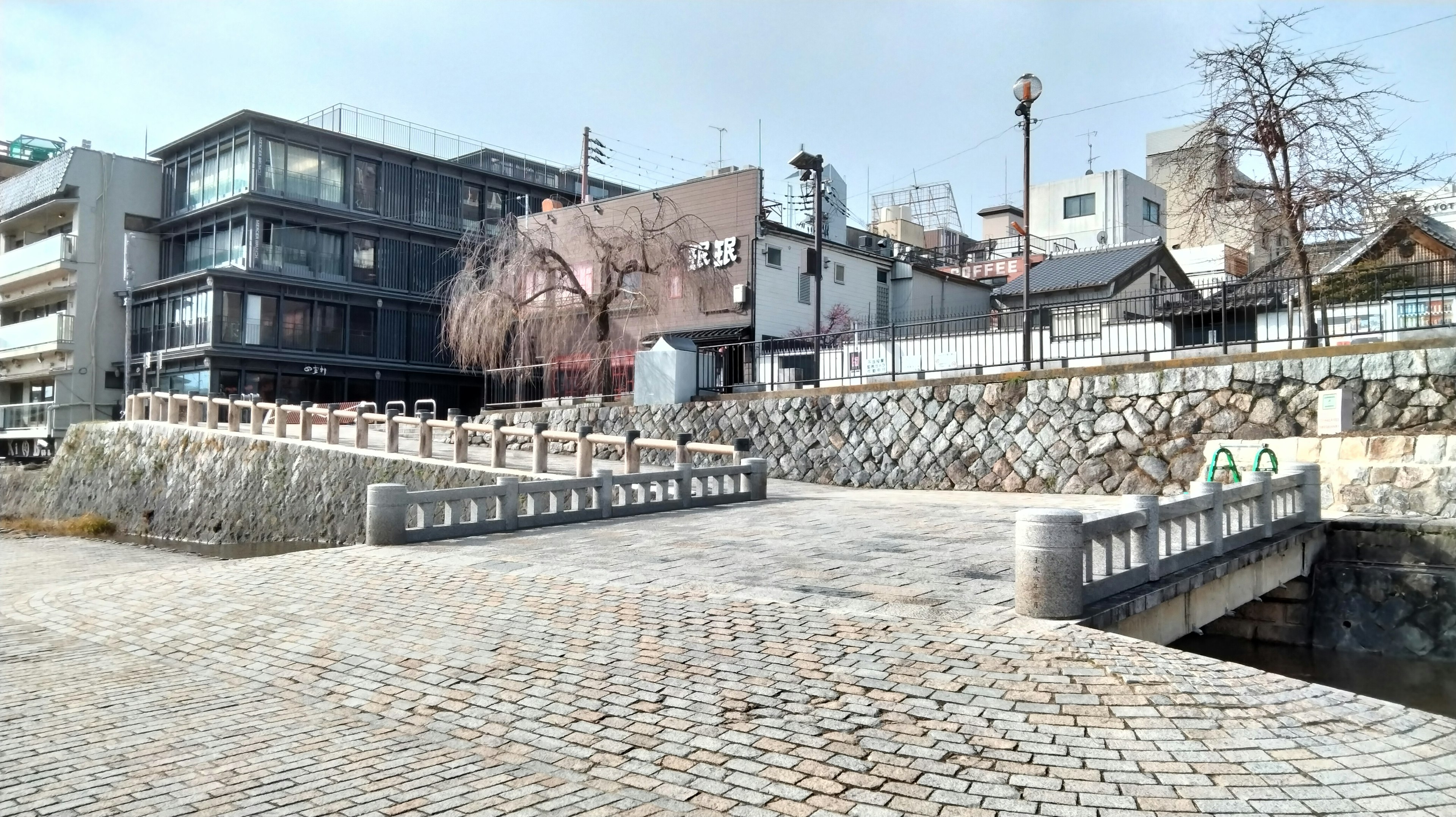 Ruhige Szene mit einer Steinbrücke und modernen Gebäuden