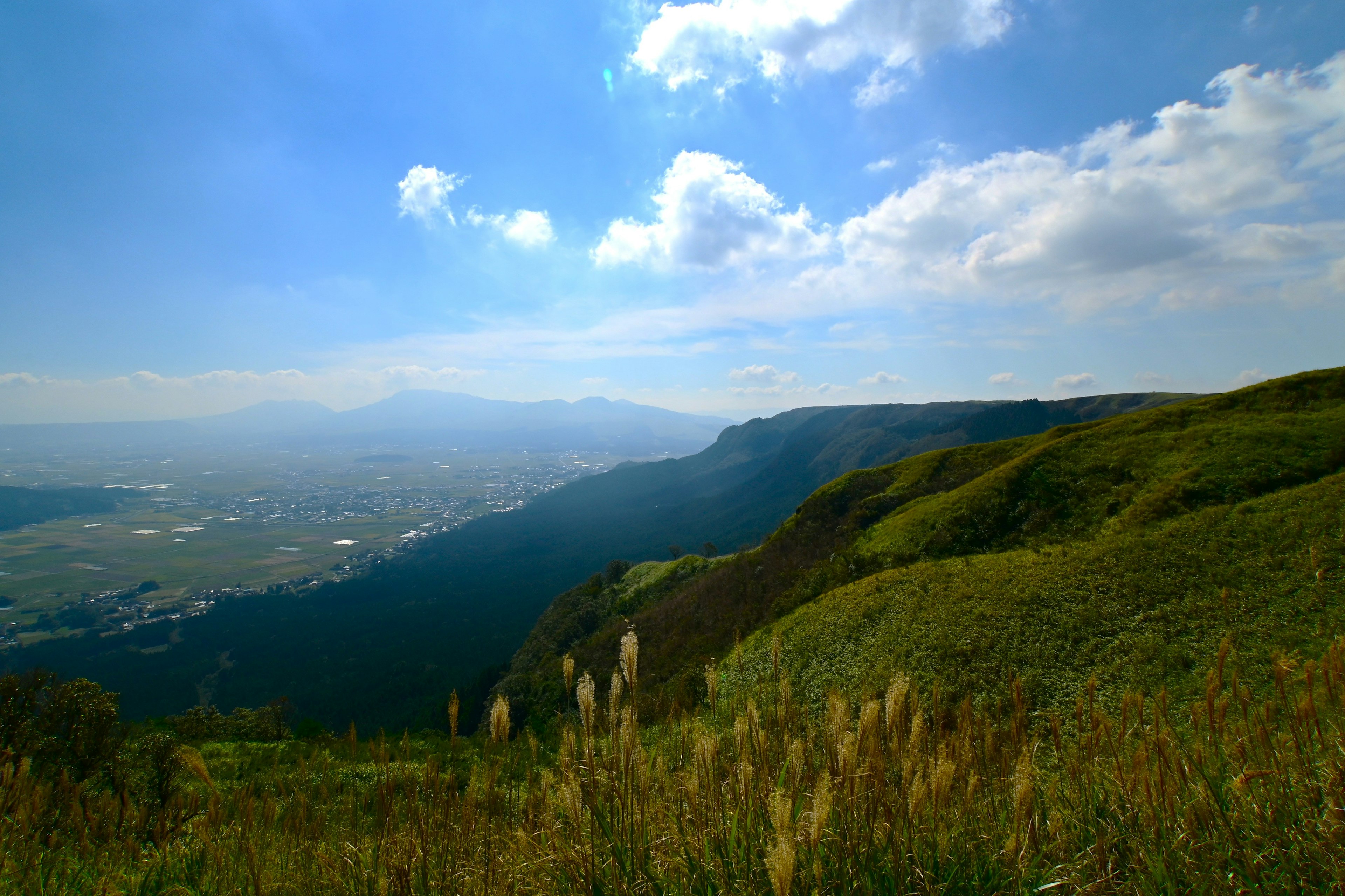 青空と雲が広がる山の風景 緑の丘と遠くの山々が見える