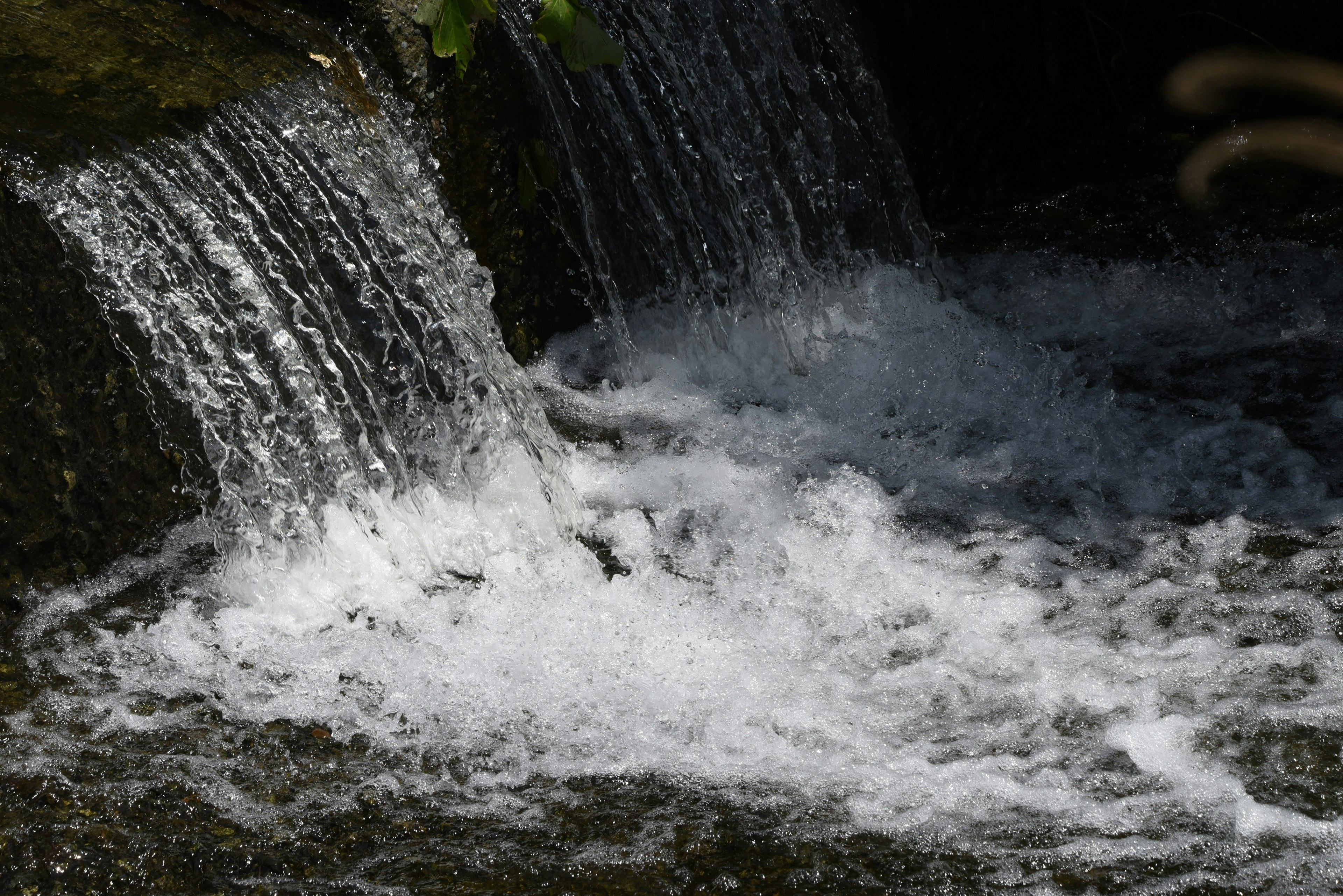 Pequeña cascada con agua fluyendo y burbujas