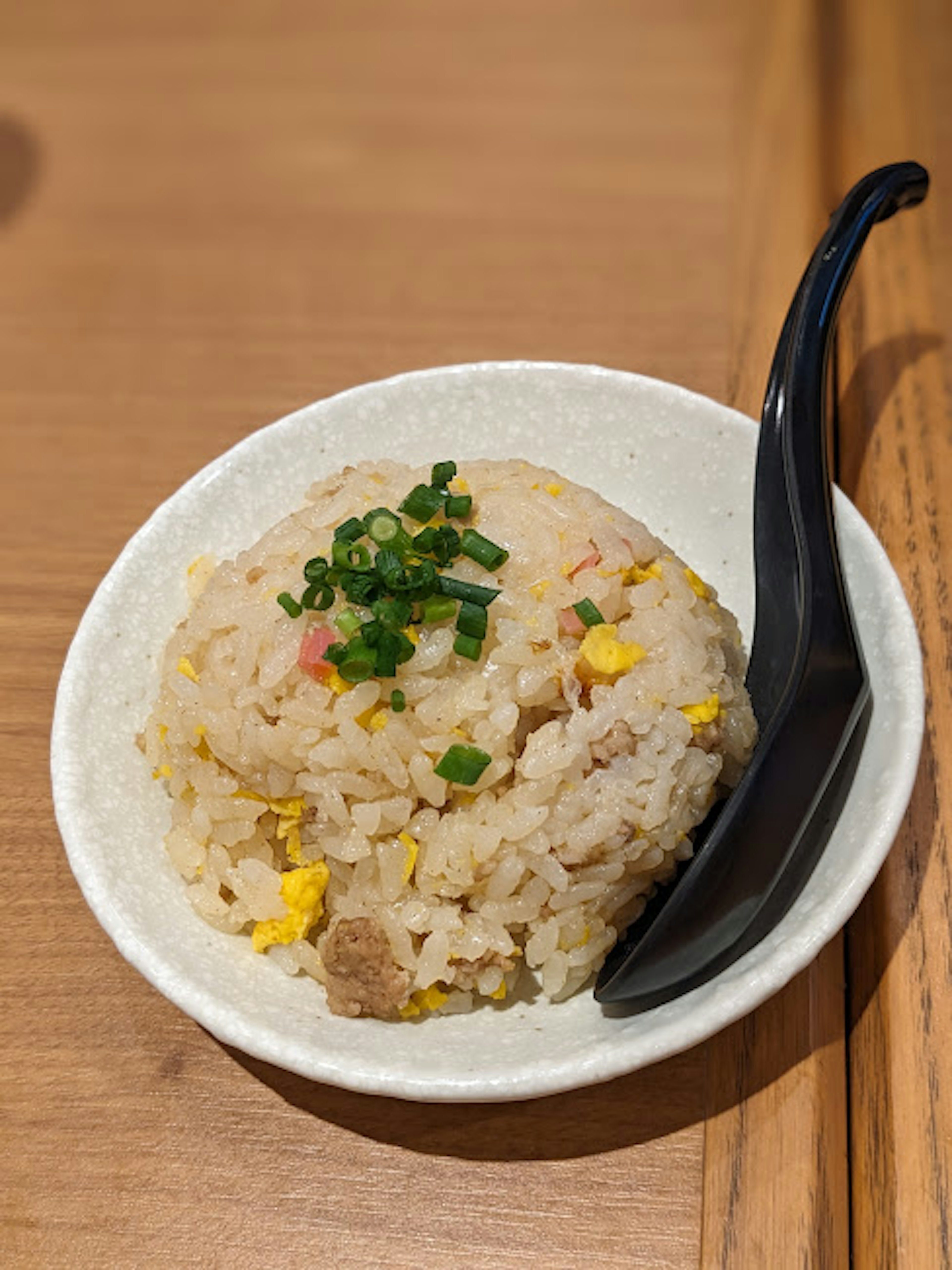 Riz frit dans un bol garni d'oignons verts hachés