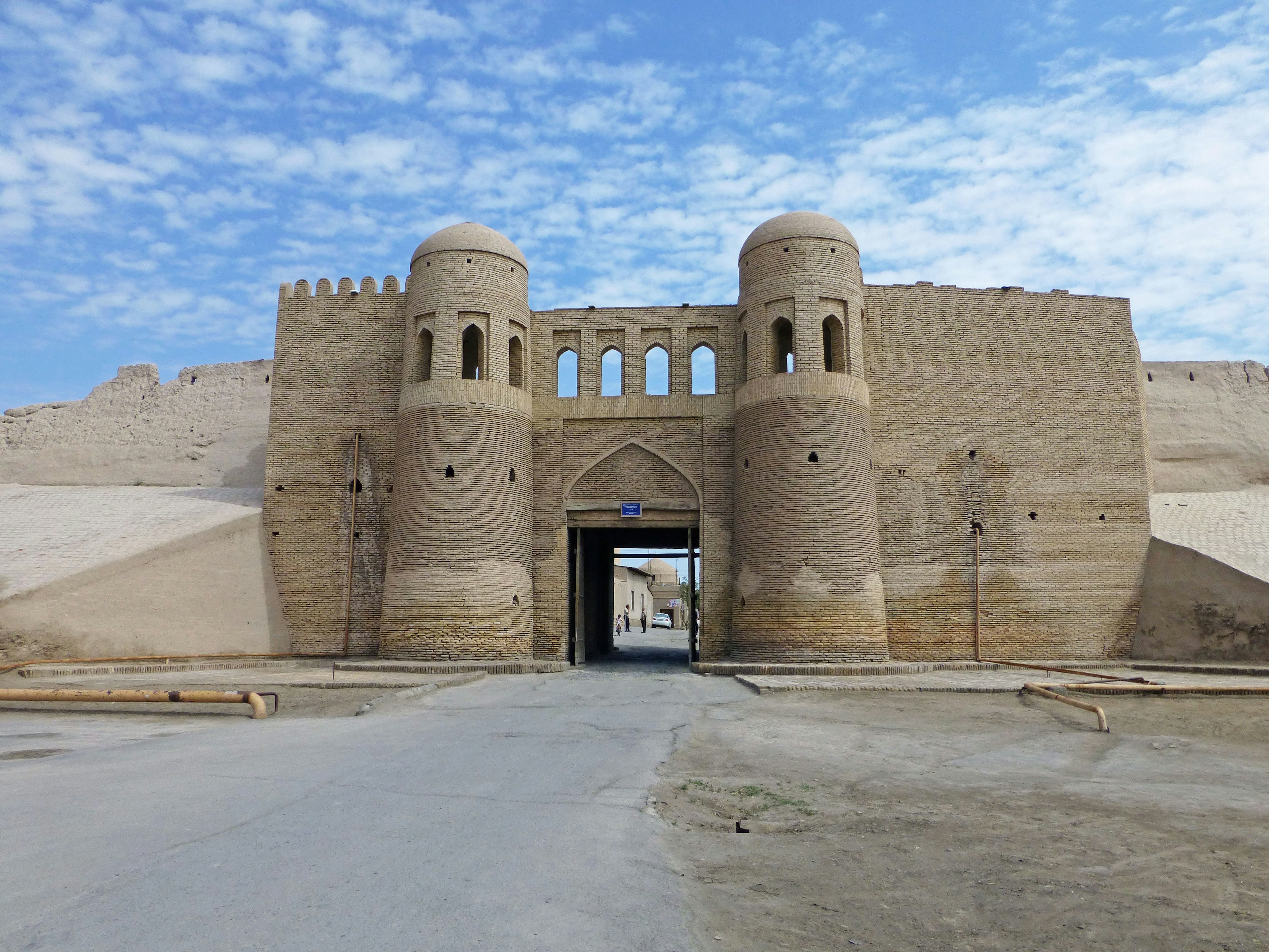 Entrance of an ancient fortress in the desert featuring walls and towers