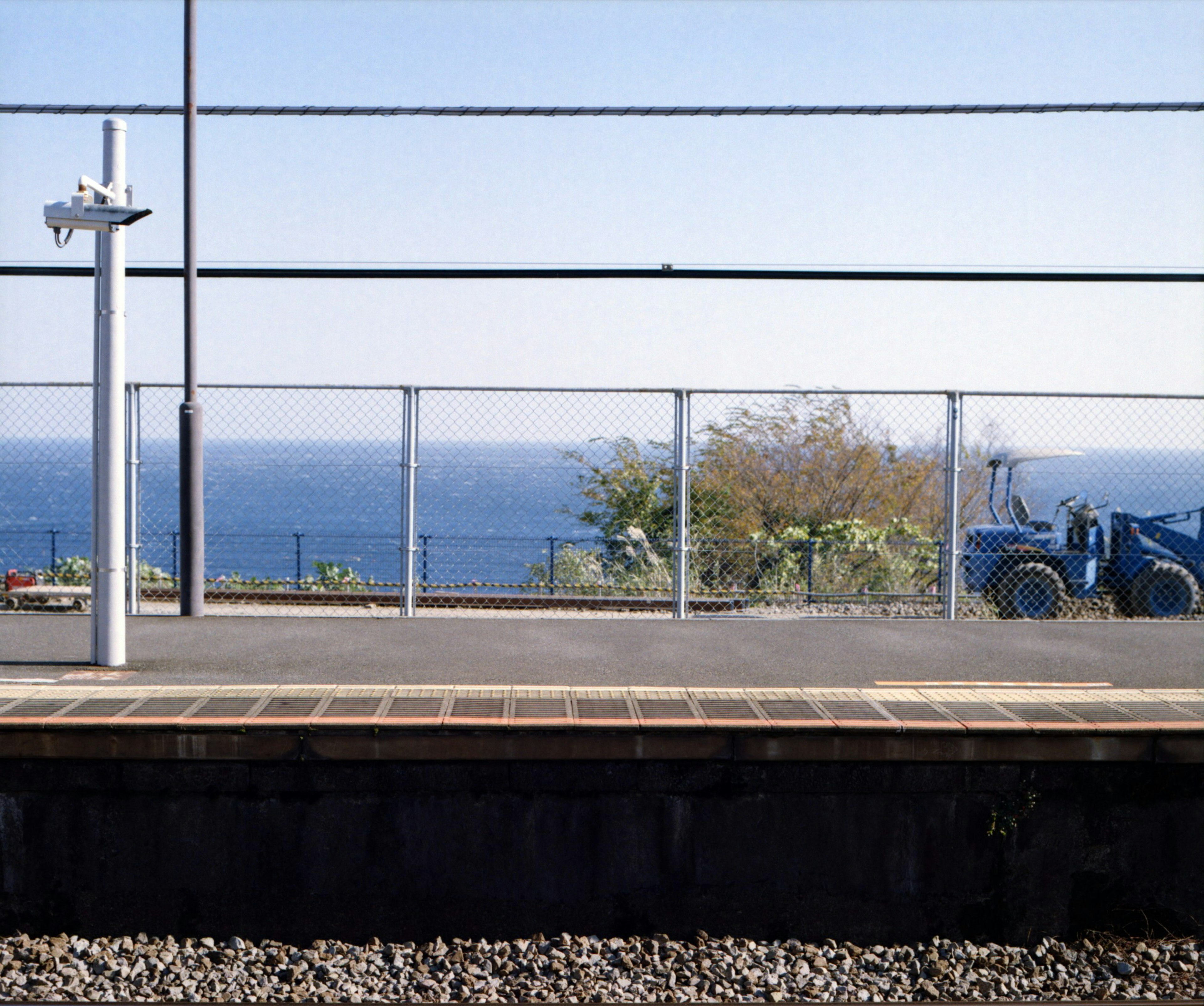 海の景色が見える駅のプラットフォームとフェンス