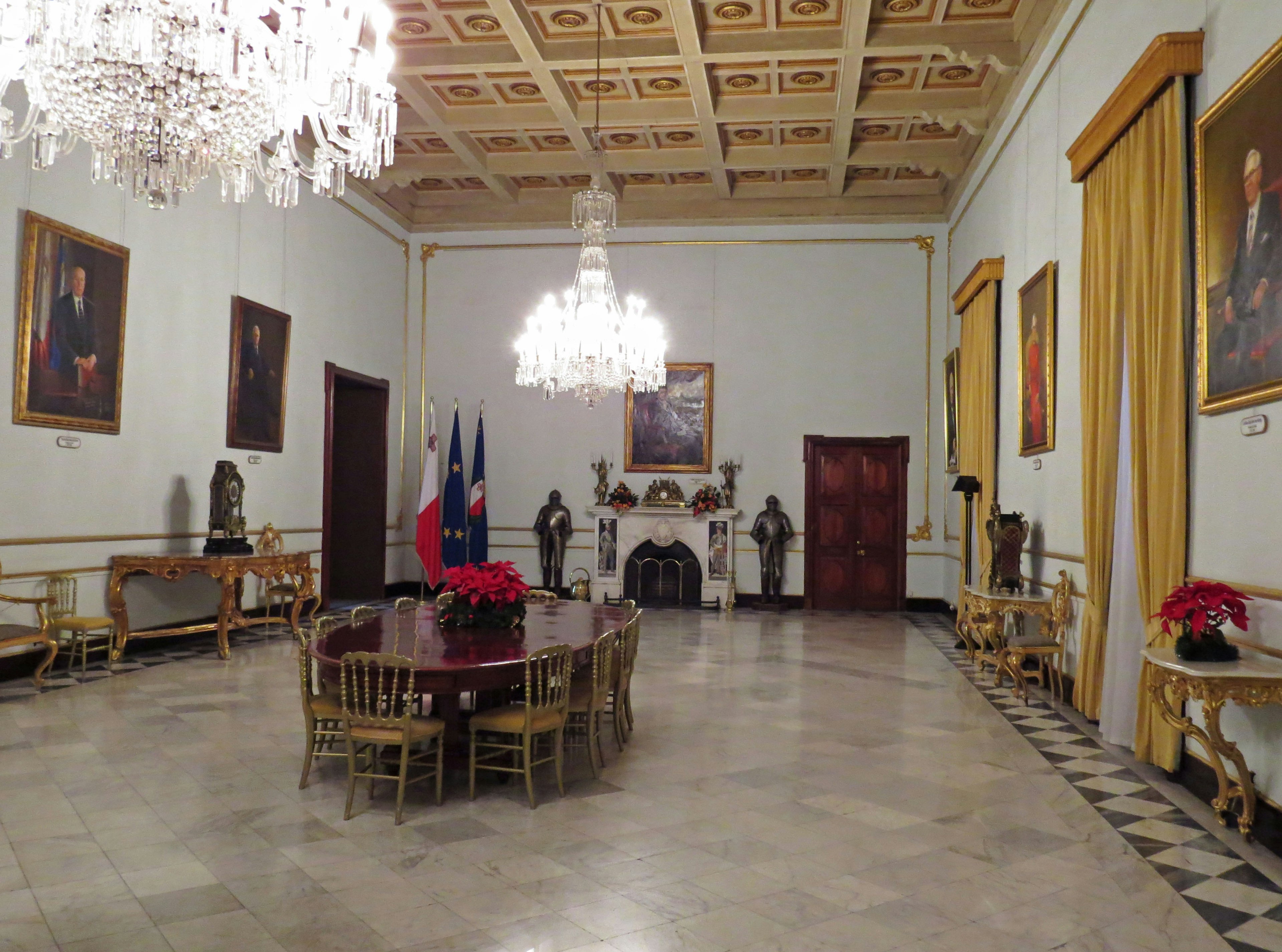 Spacious room with a luxurious chandelier and framed portraits