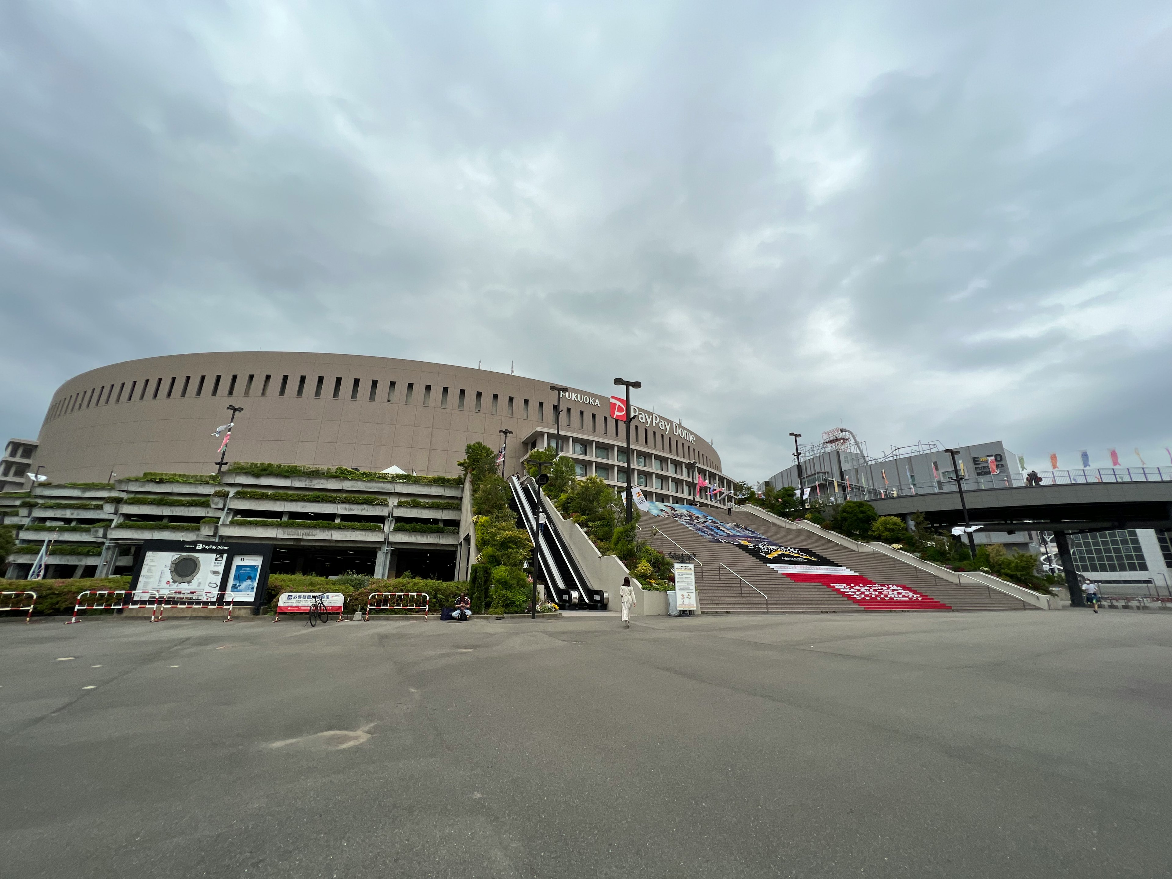 大きなスタジアムと曇った空を背景にした広い駐車場の風景