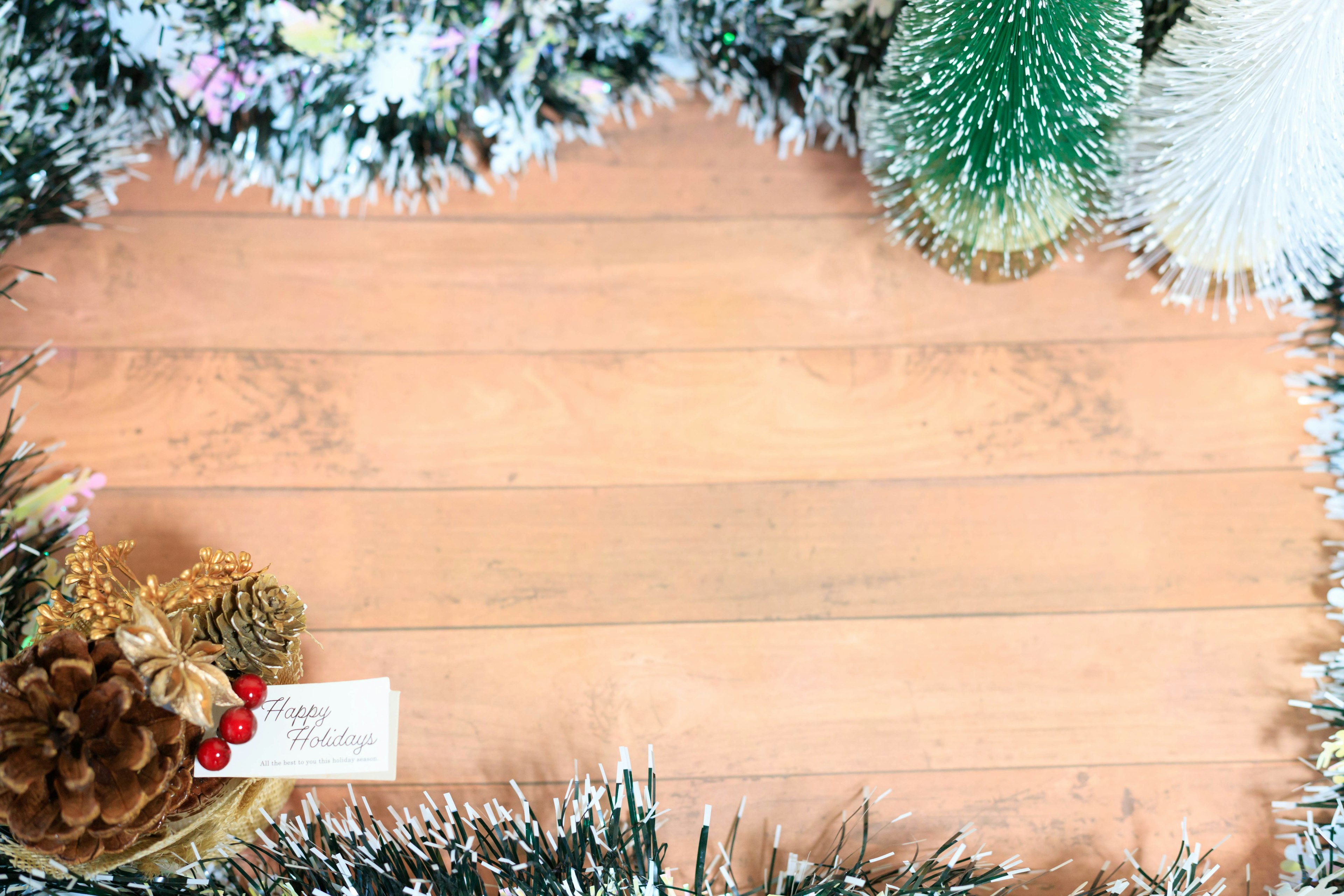 Mesa de madera decorada con vegetación navideña y piñas