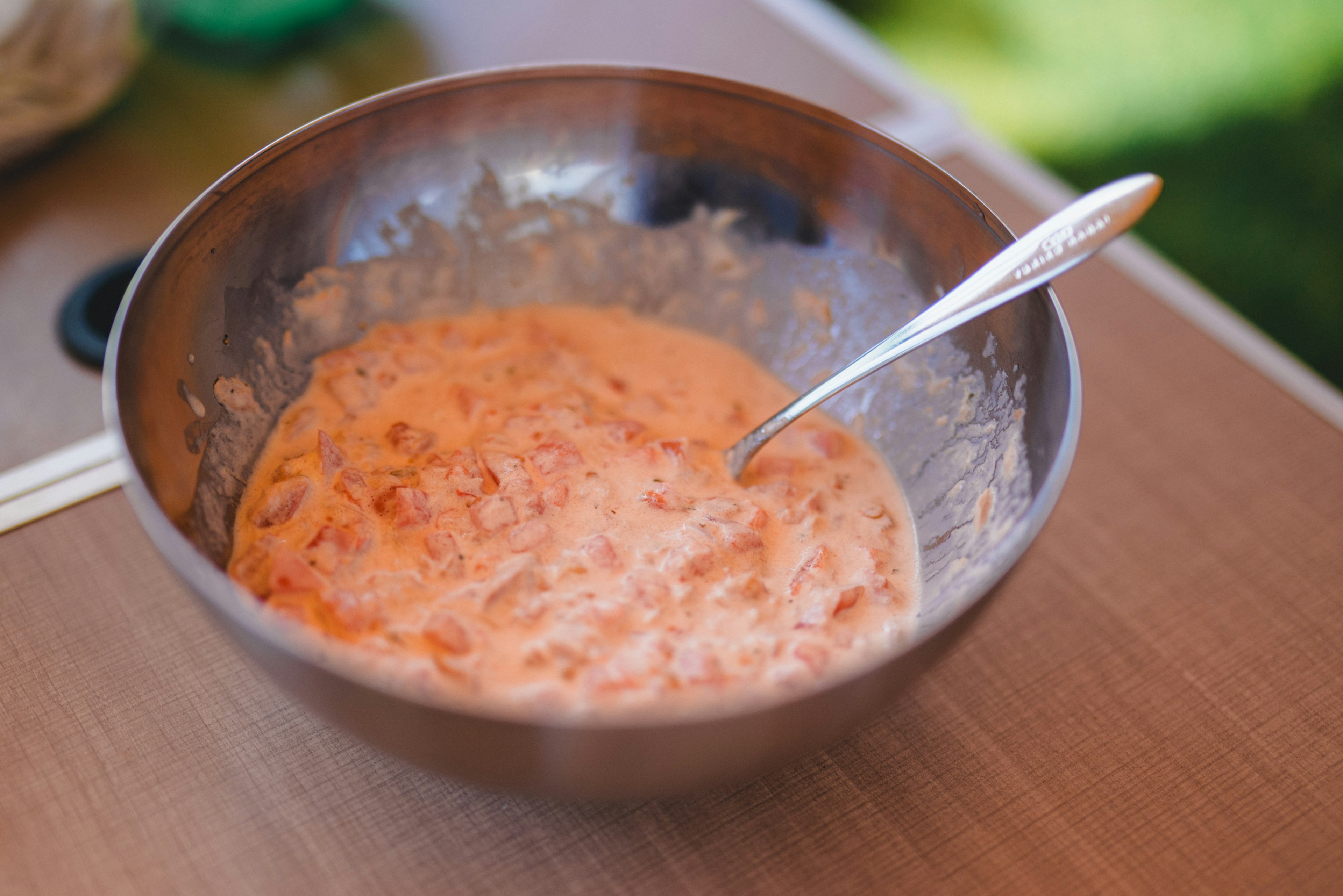 Schüssel mit orangem cremigem Gemisch und einem Löffel