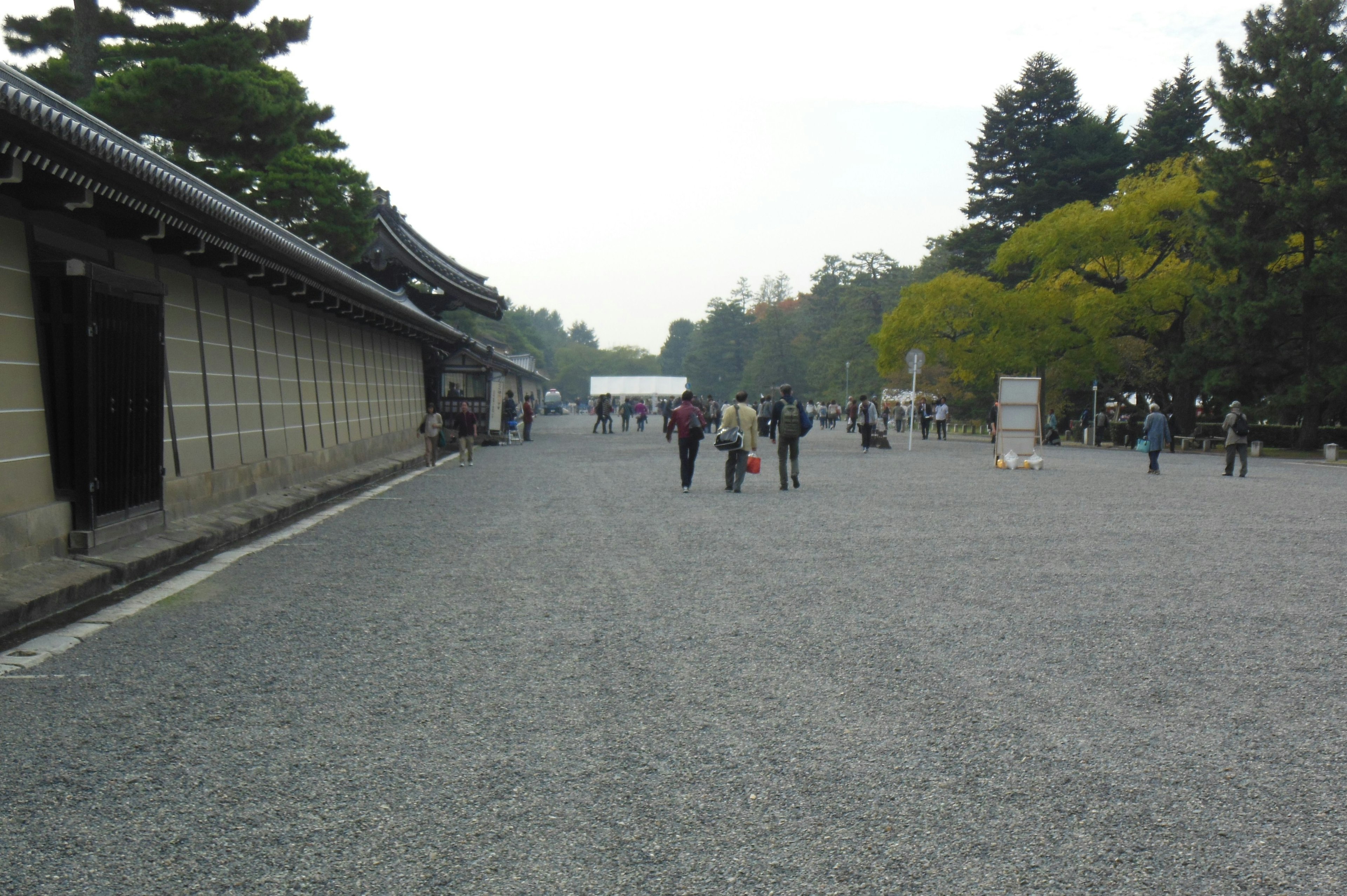 Scenic view of people walking in a quiet garden with traditional buildings