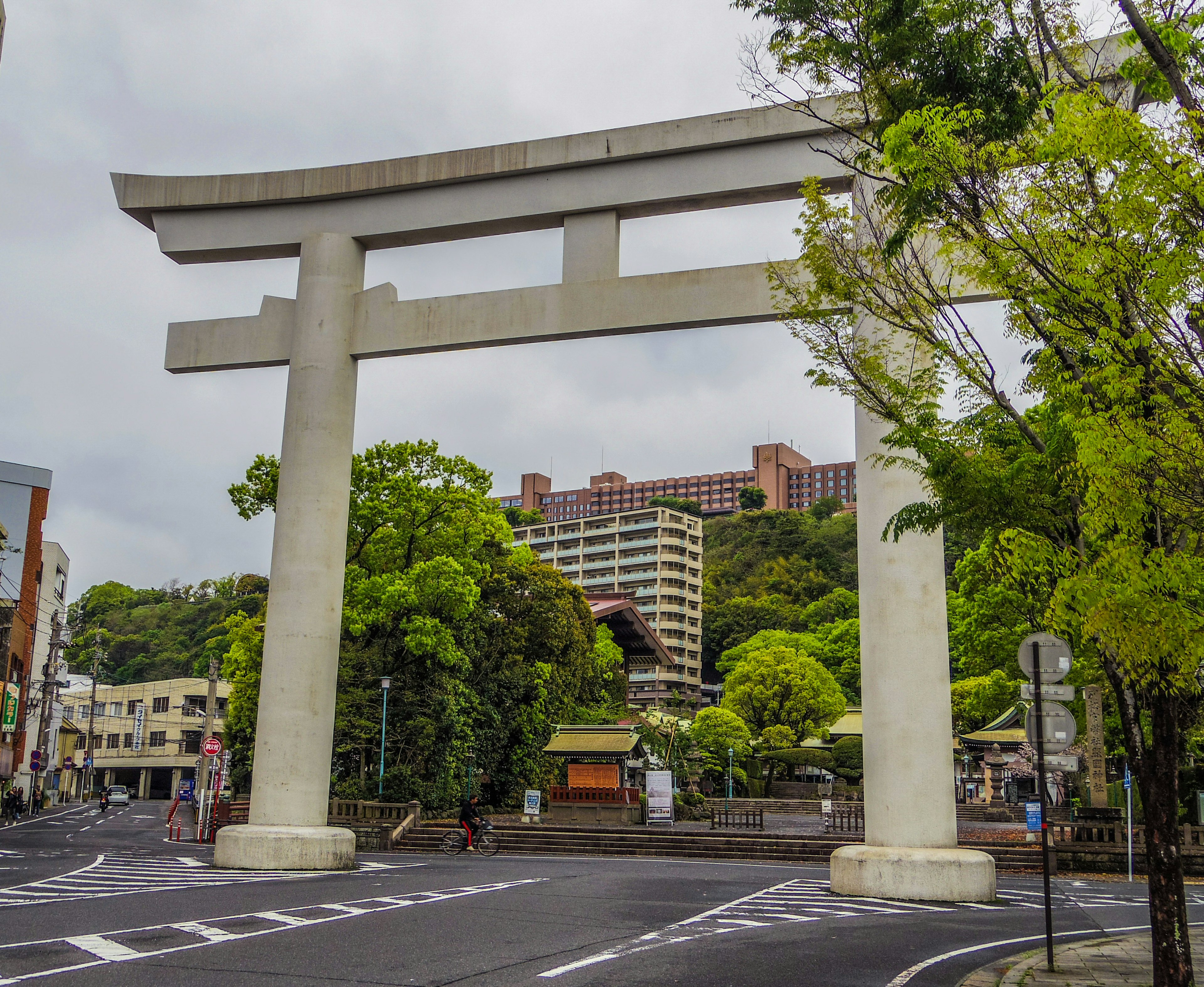 大きな鳥居と緑豊かな風景が特徴の都市の交差点