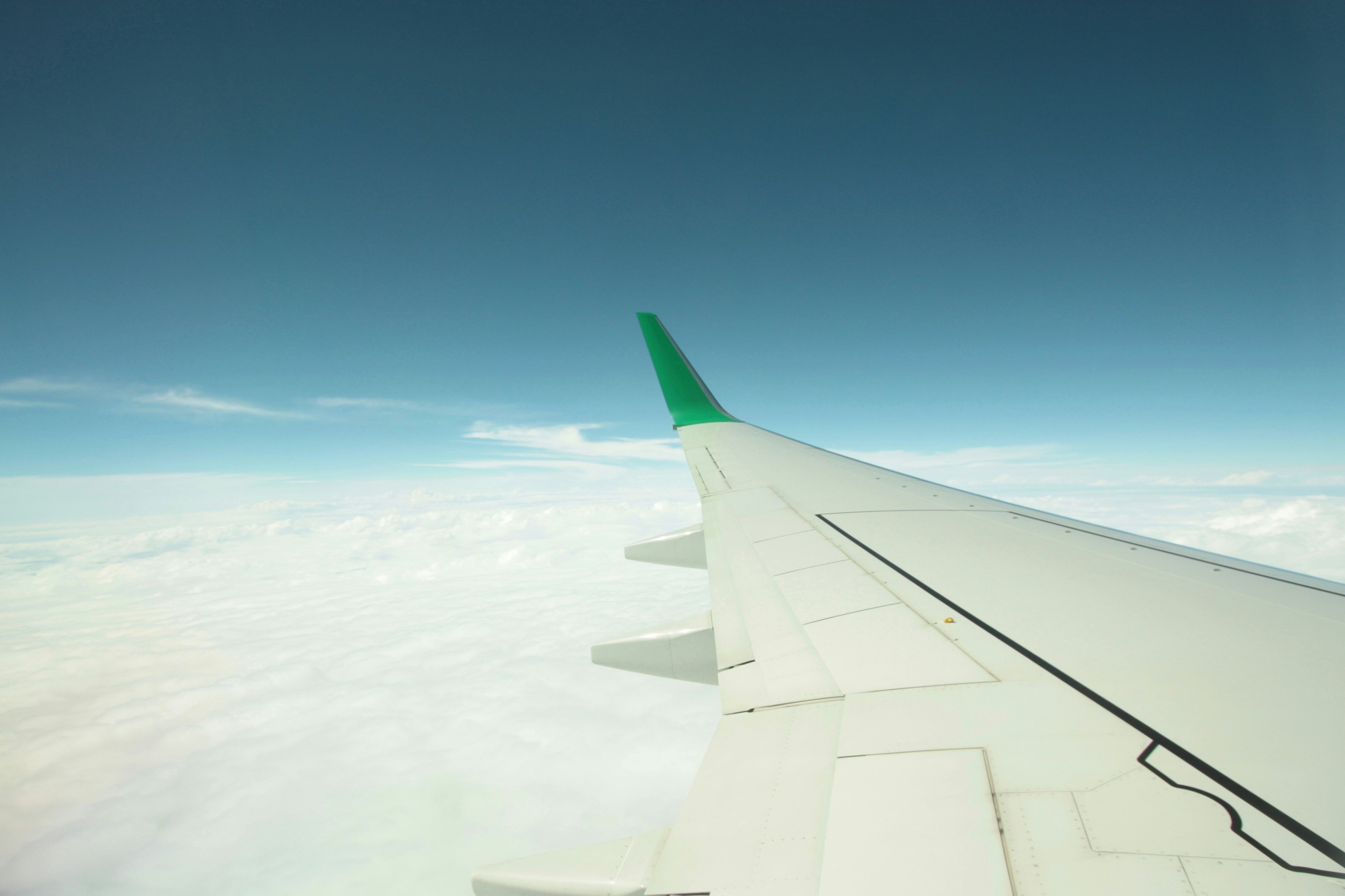 Airplane wing with clouds and blue sky