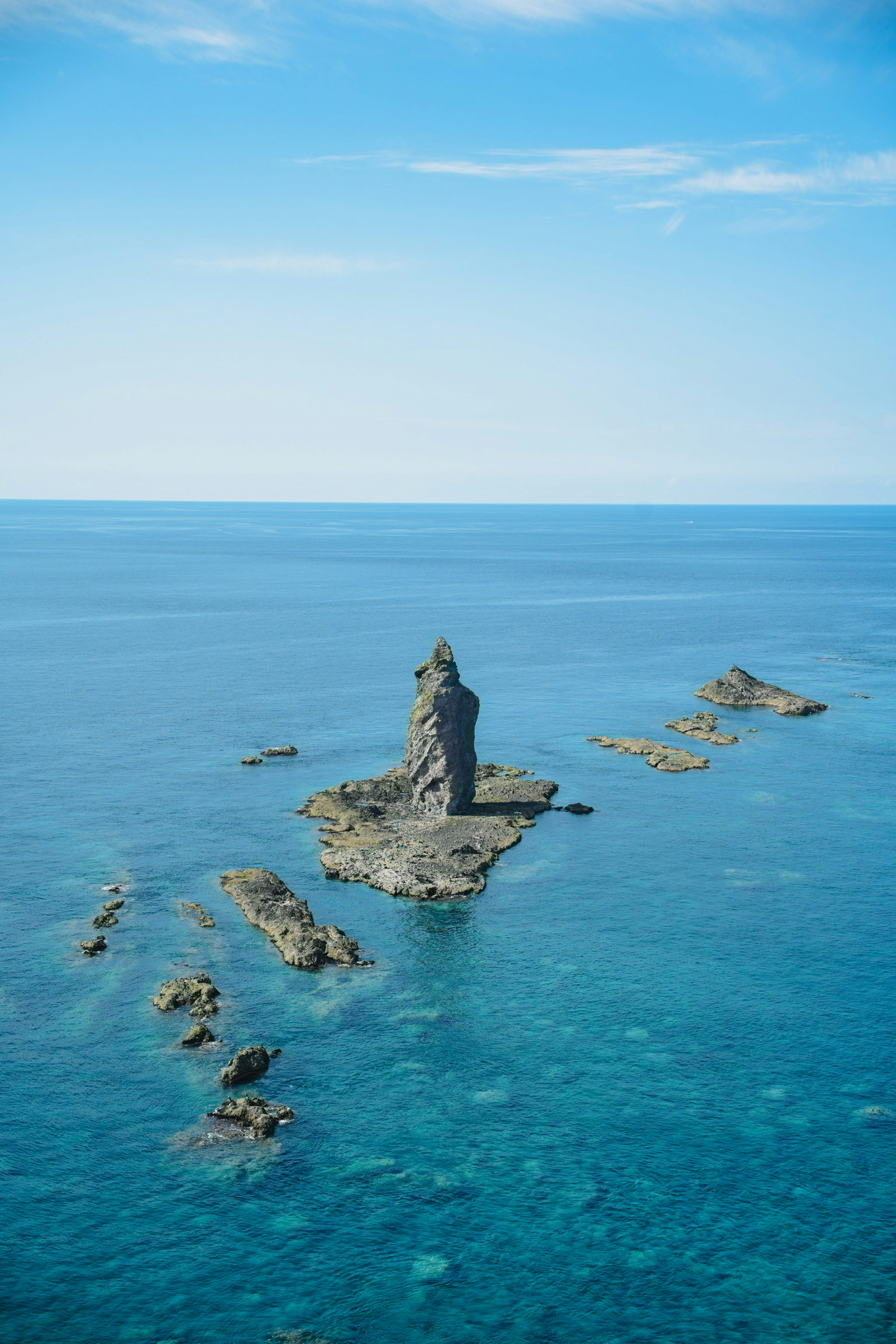 Vue pittoresque d'une île rocheuse se tenant dans des eaux océaniques bleues