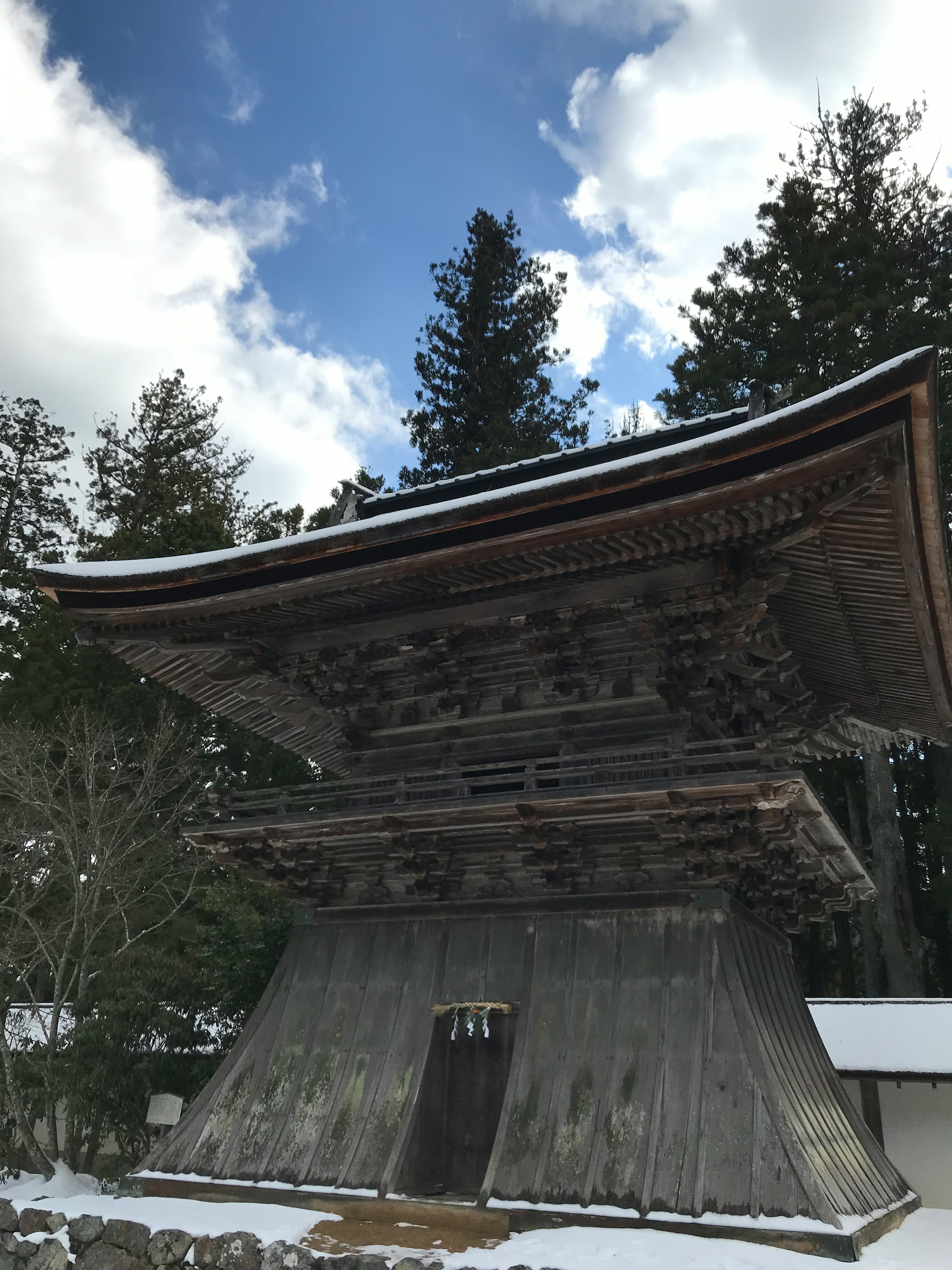 雪に覆われた木造の寺院の門と青空の背景