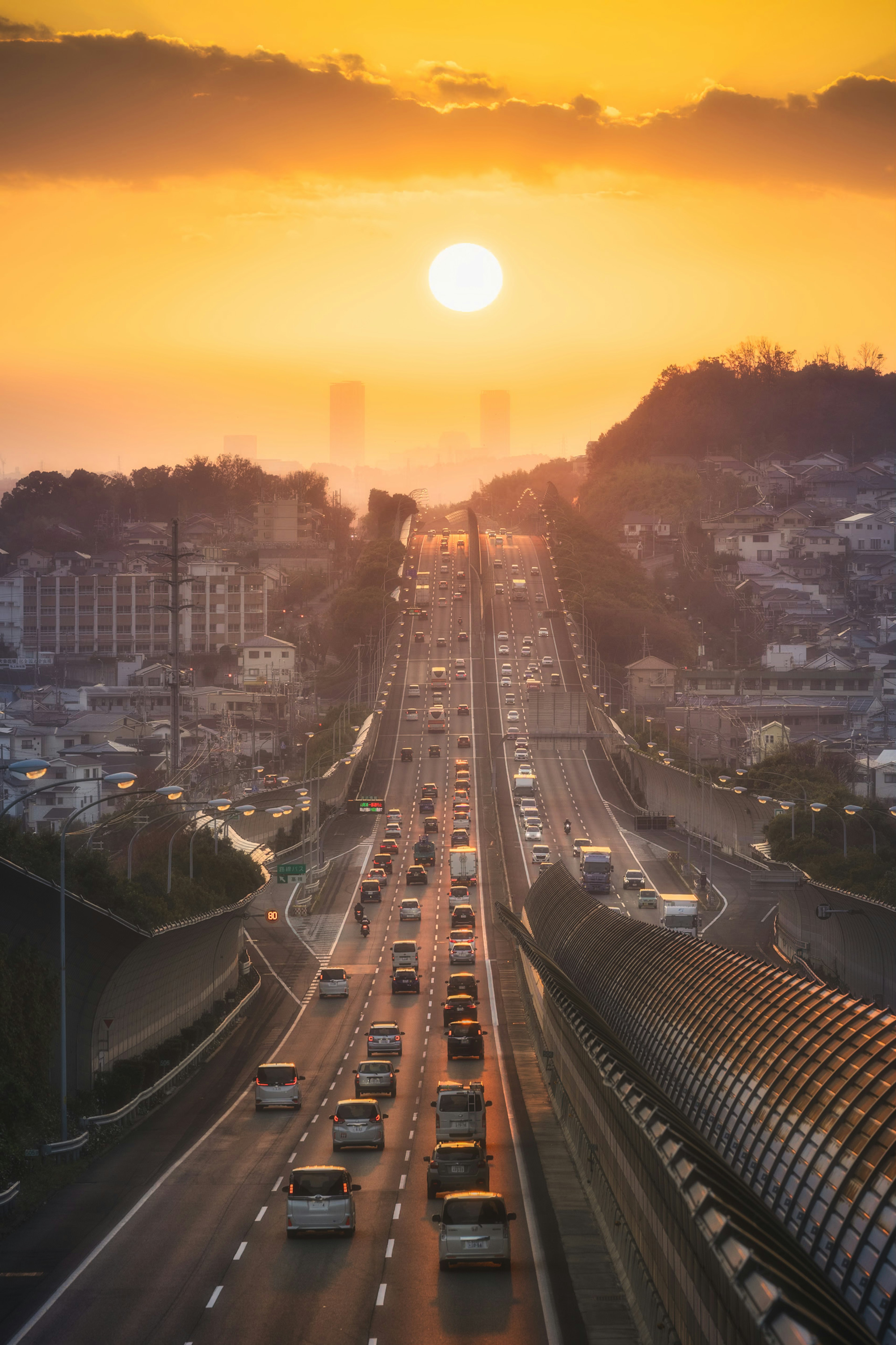 Escena de carretera al atardecer con coches y paisaje urbano