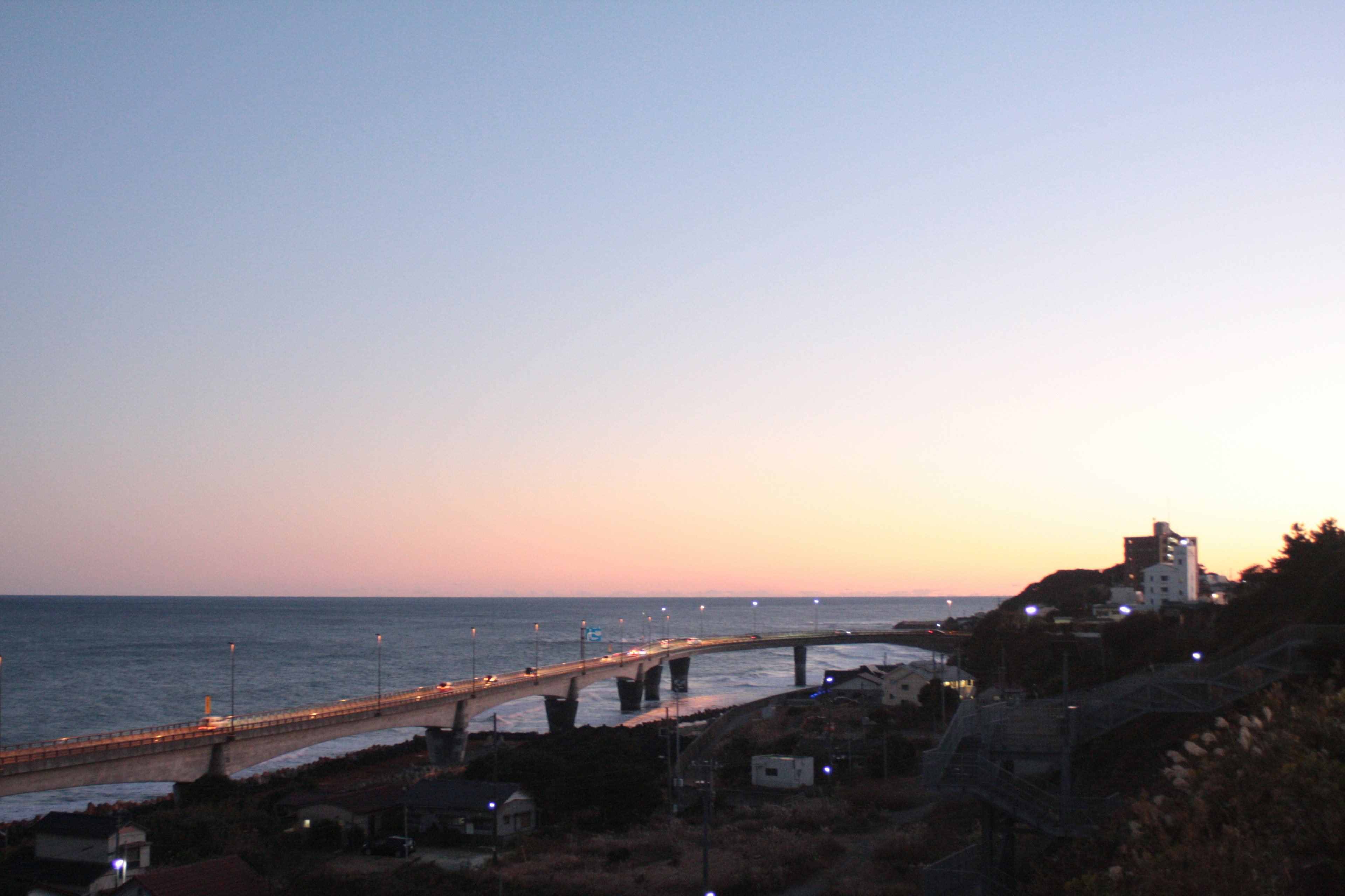 Vista costera al atardecer con un puente y la costa