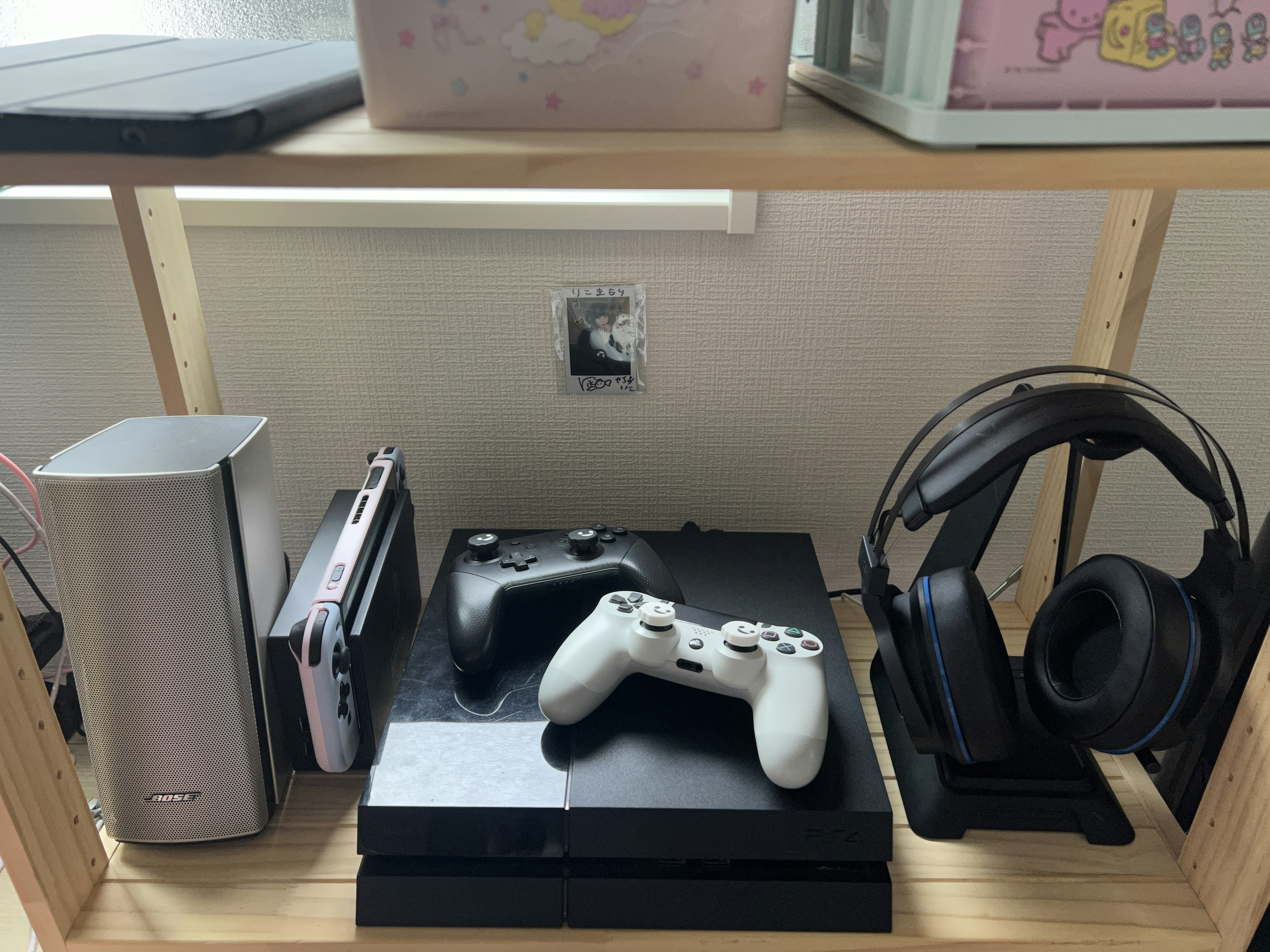 A shelf displaying gaming consoles and controllers