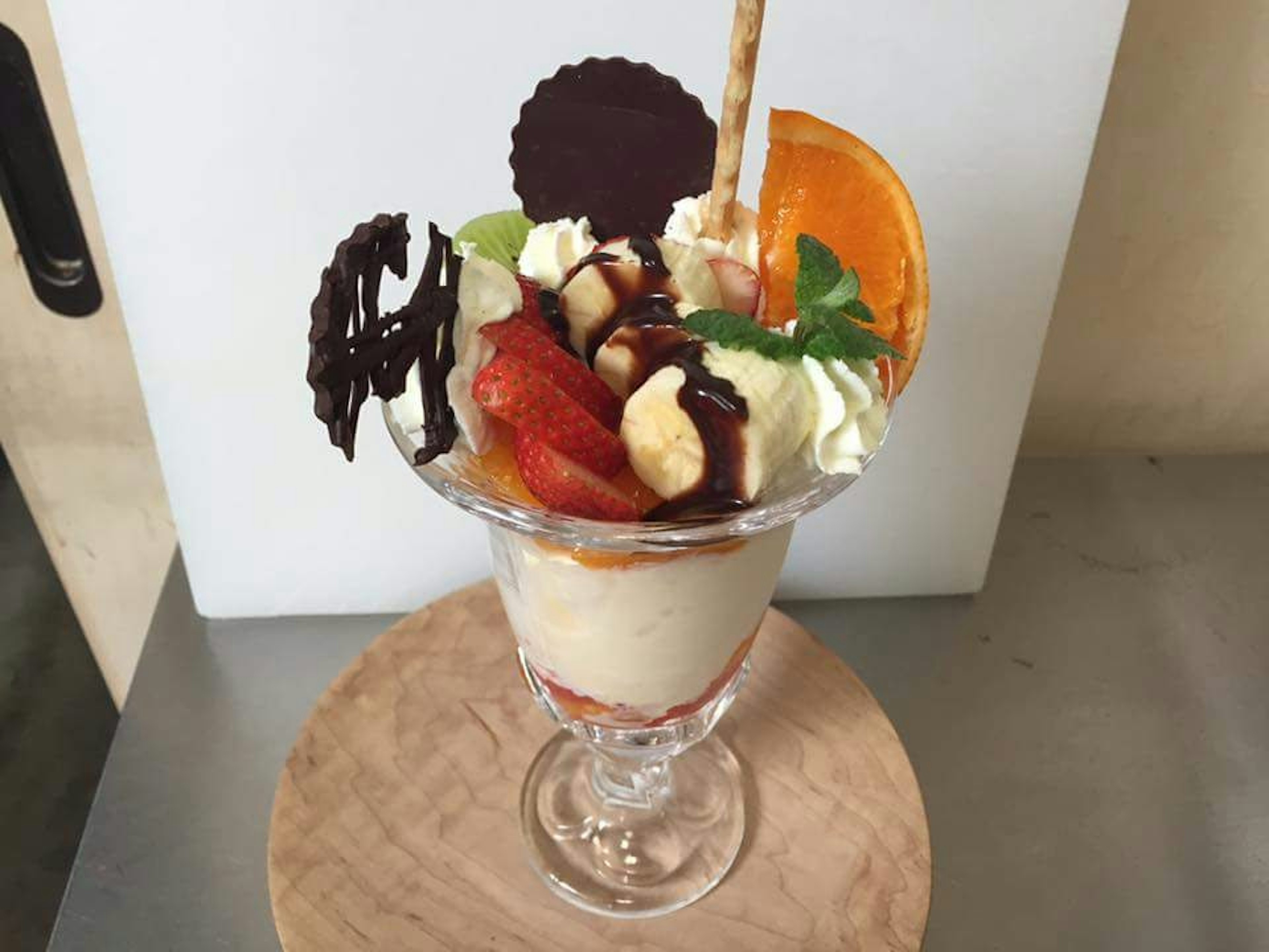 A beautiful dessert parfait topped with fruits and chocolate